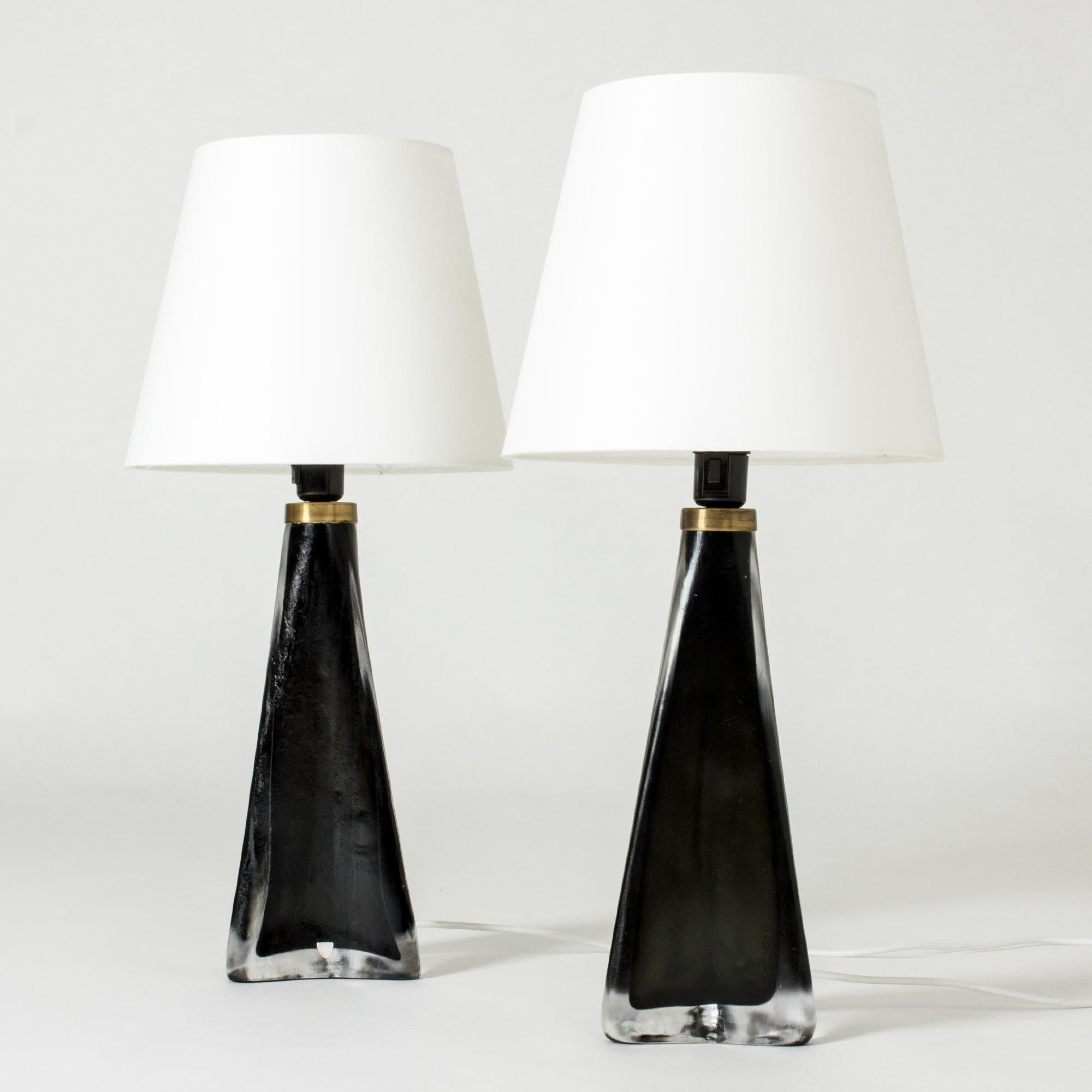 Pair of cool and luxurious table lamps by Carl Fagerlund, made in striking black and clear glass. Tapering shape with a triangular base. Slightly frosted surface with structure.