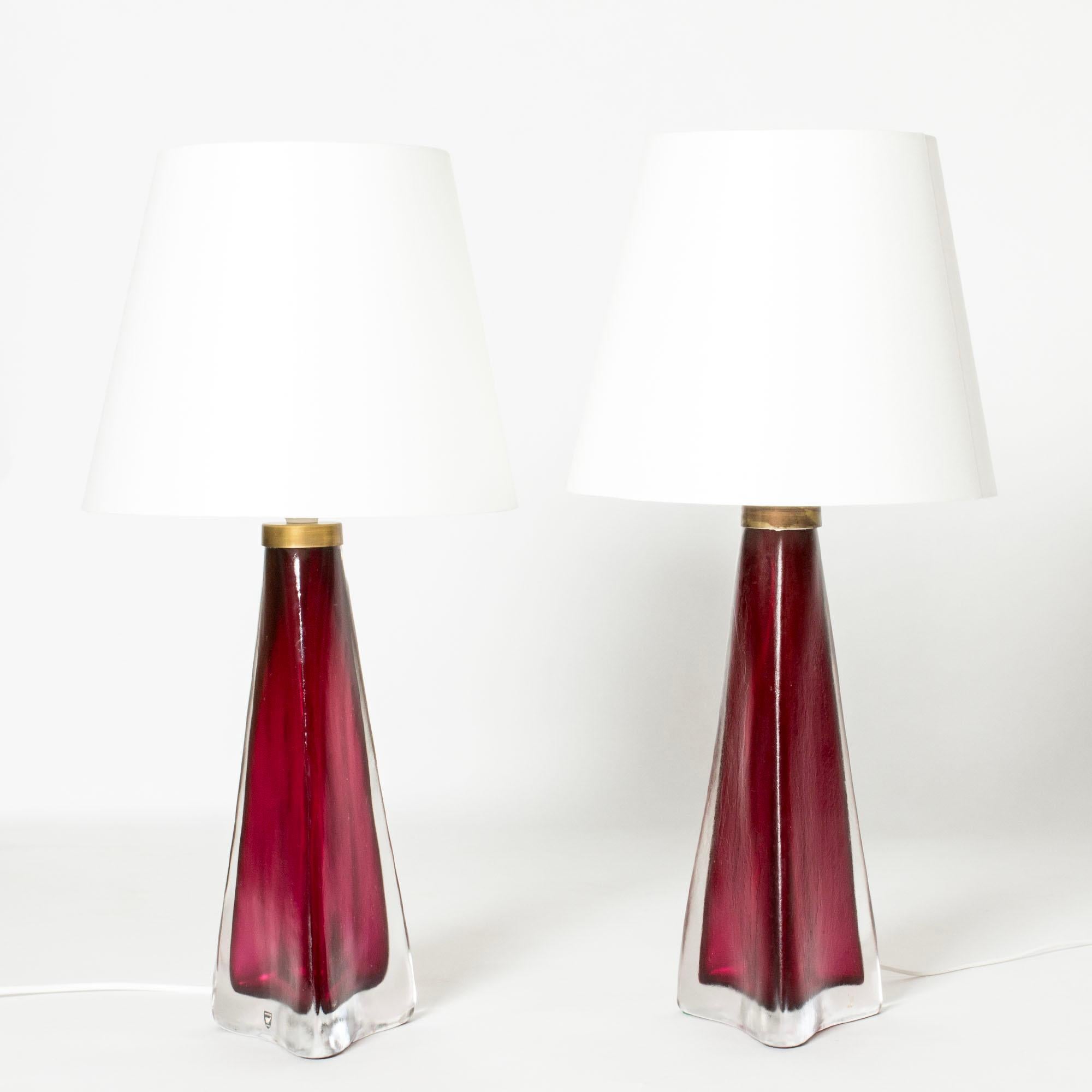 Paire de lampes de table cool et luxueuses de Carl Fagerlund, en verre transparent et rouge framboise. Forme effilée avec une base triangulaire. Surface légèrement givrée avec structure.