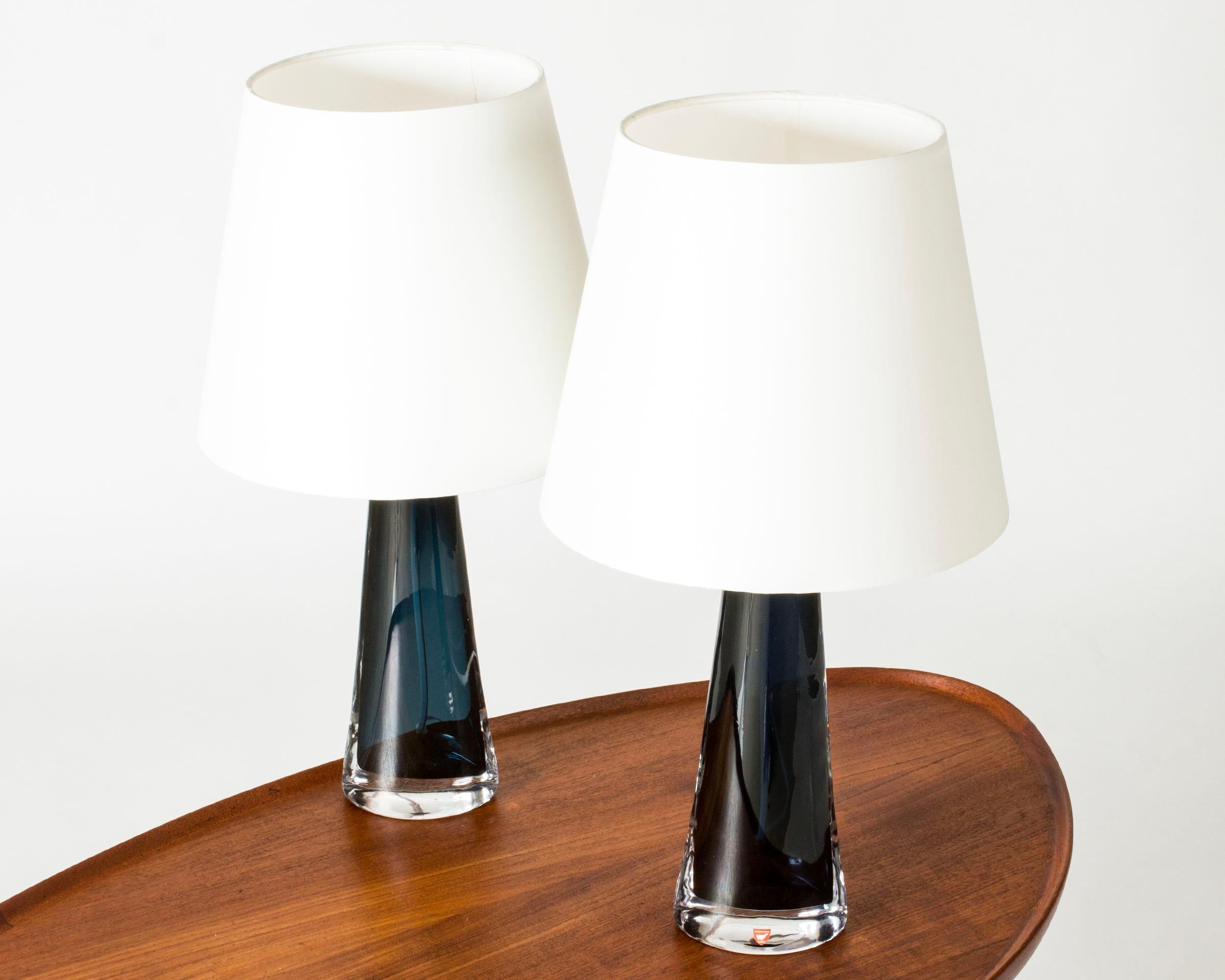 Pair of crystal glass table lamps by Carl Fagerlund, made from dark blue colored glass in a narrow conical shape, almond shaped at the base. Beautiful translucent color, elegant design.