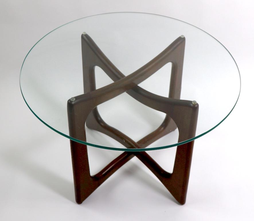 Circular glass top table with sculpted wood base designed by Adrian Pearsall. This example is in very good original condition, clean and ready to use. Glass top 5/8 inch thick.
