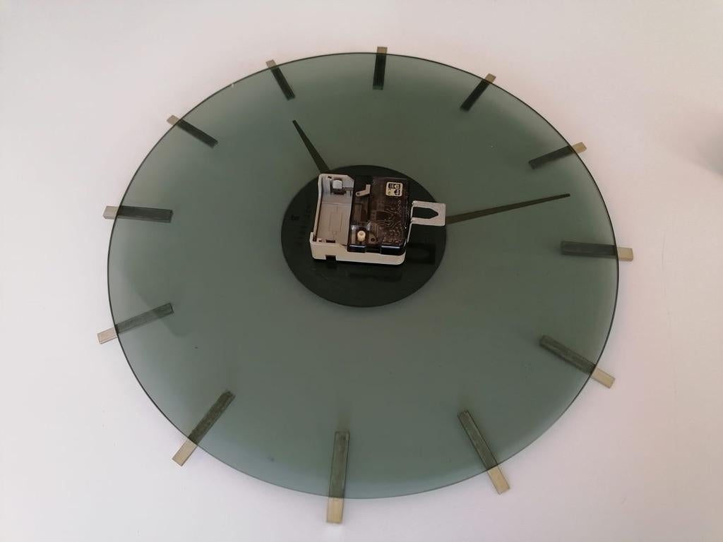 Smoked glass clock face with nickel plated clock hands and indexing. Made in Germany by Junghans in the early 1960s. Fitted with a battery movement.