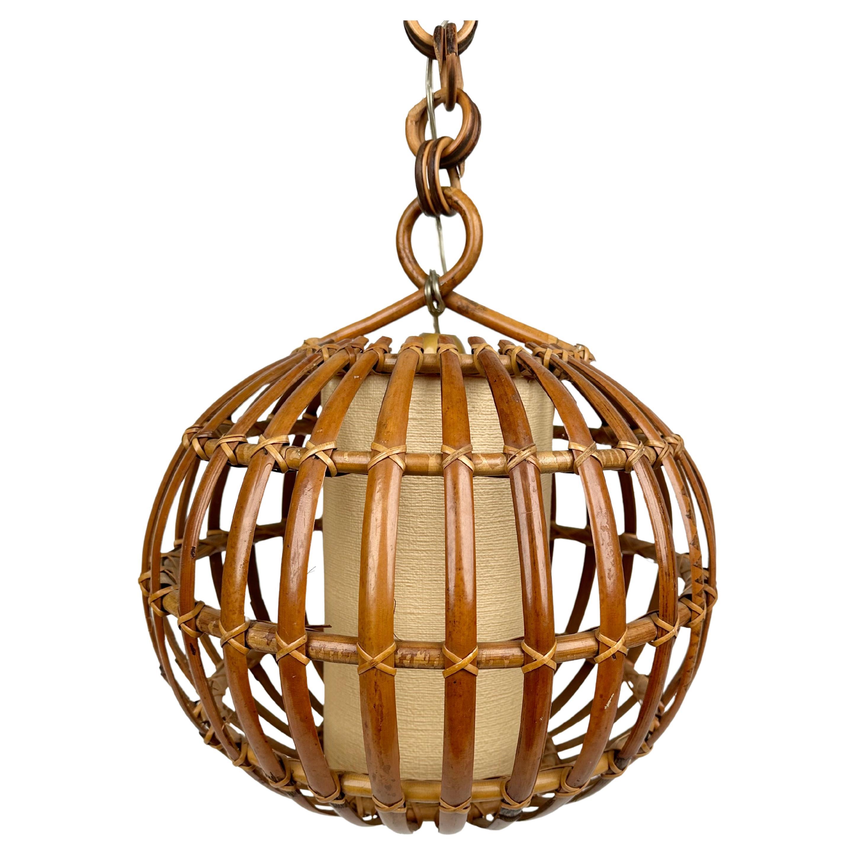 Midcentury lantern in rattan and bamboo with globe or ball shaped lampshade. 

Made in Italy in the 1960s. 

This suspension lamp is entirely handcrafted with rattan and bamboo. The ball shaped shade hangs from a chain with round rattan links which