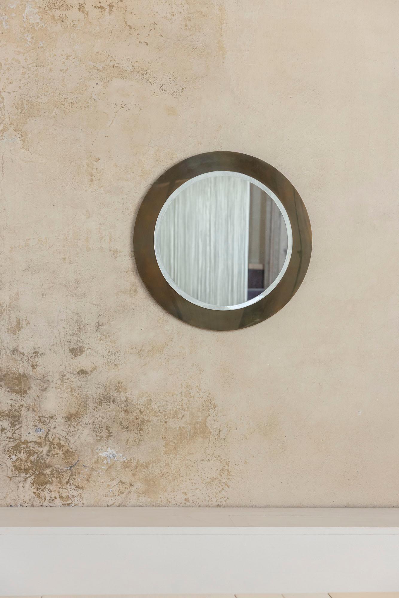 Elegant miroir mural rond avec son cadre et sa vitre d'origine, fabriqué en Italie vers 1960.
Le miroir présente un cadre en laiton doré avec une patine chaude et vieillie qui met en valeur son attrait intemporel. Un exemple raffiné du design