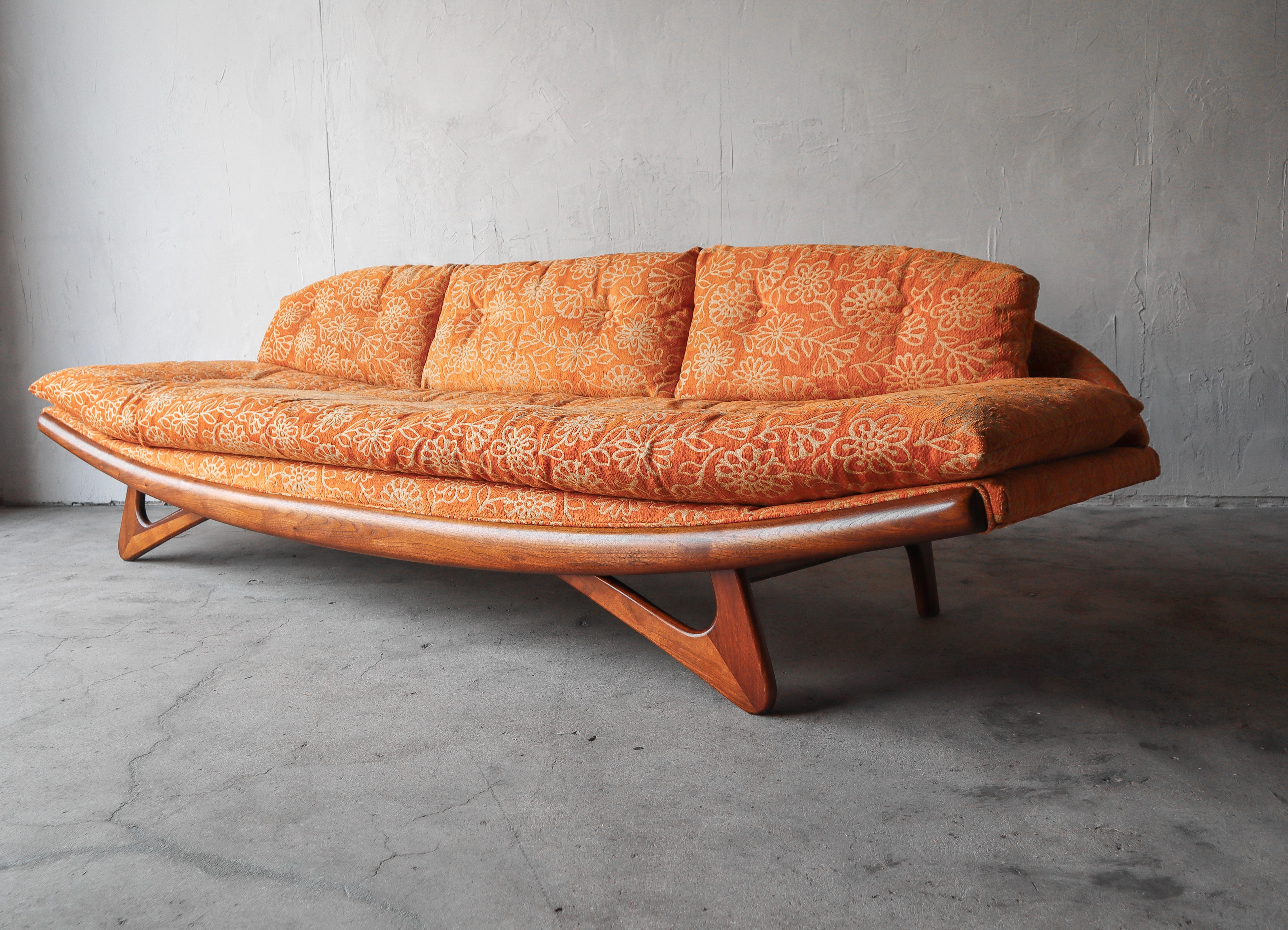 Original mid century gondola sofa by Adrian Pearsall.

Sofa is being sold as found. The walnut base is in excellent condition and the frame is solid. The fabric looks ok on a whole but has seen better days, reupholstery needed.