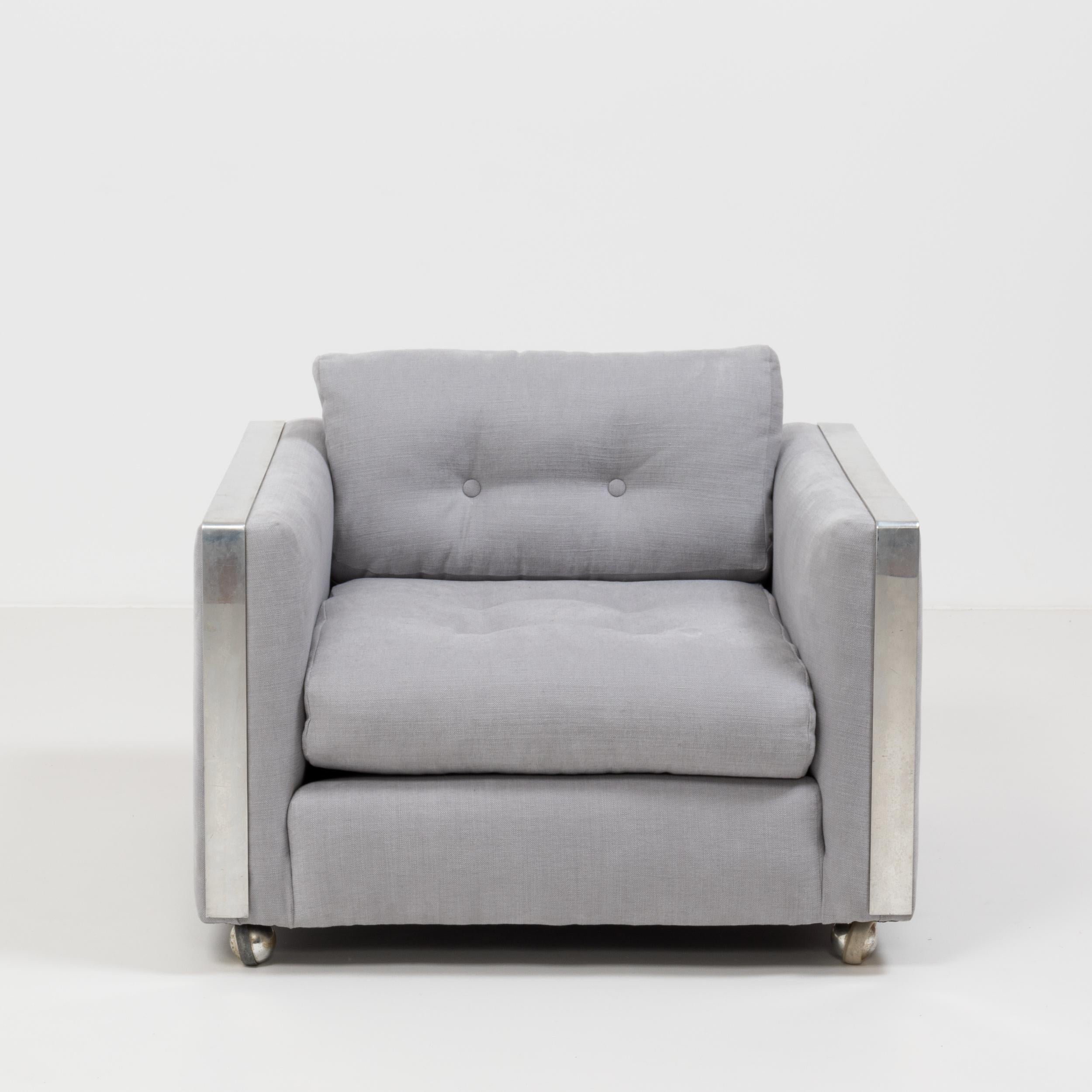 Designed in the style of Milo Baughman, this sleek midcentury armchair has been newly upholstered in a sumptuously soft and airy grey Linara fabric that compliments the chrome detailing perfectly.
 
With its clean lines and cool aesthetic it