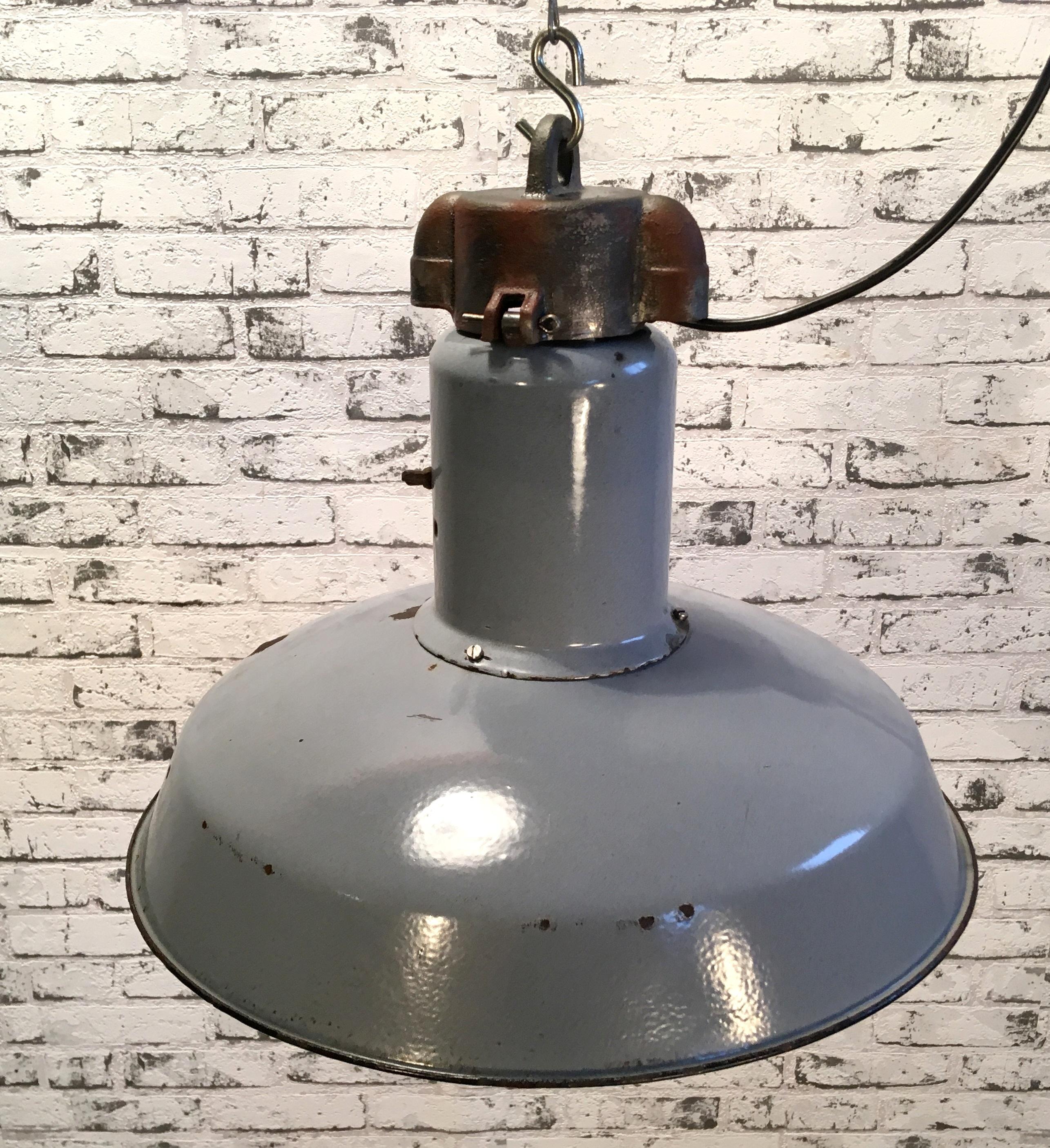 This industrial  grey enamel pendant lamp was manufactured during the 1950s in former Czechoslovakia. Lamp has white enamel interior and cast iron top. New porcelain socket for E 27 lightbulbs and new wire. Fully functional.