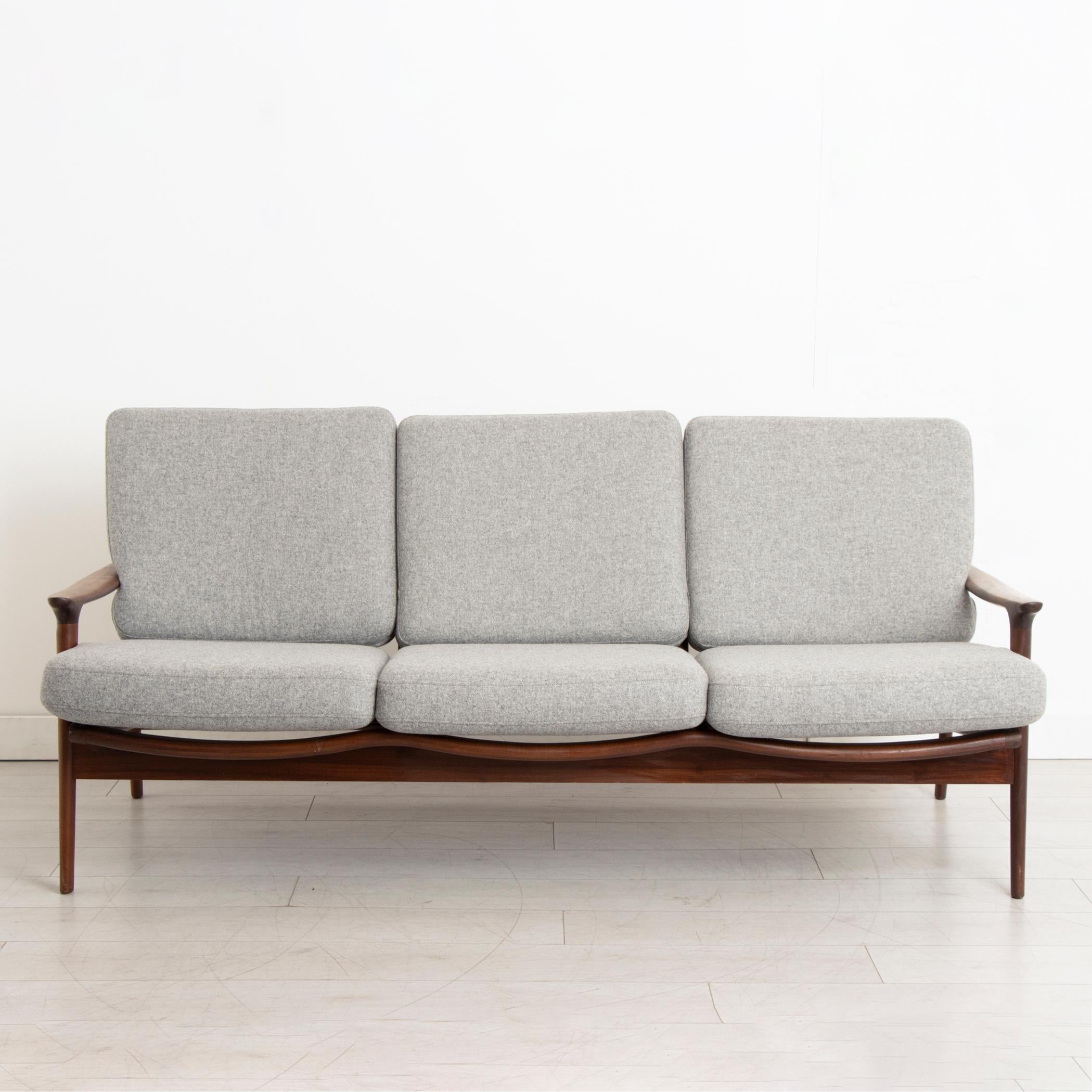 

A midcentury living room suite designed by Guy Rogers. The suite is part of the New Yorker range designed in the 1960s and includes a three-seater sofa and a pair of his and her armchairs. Made in solid afrormosia with new webbing and cushions