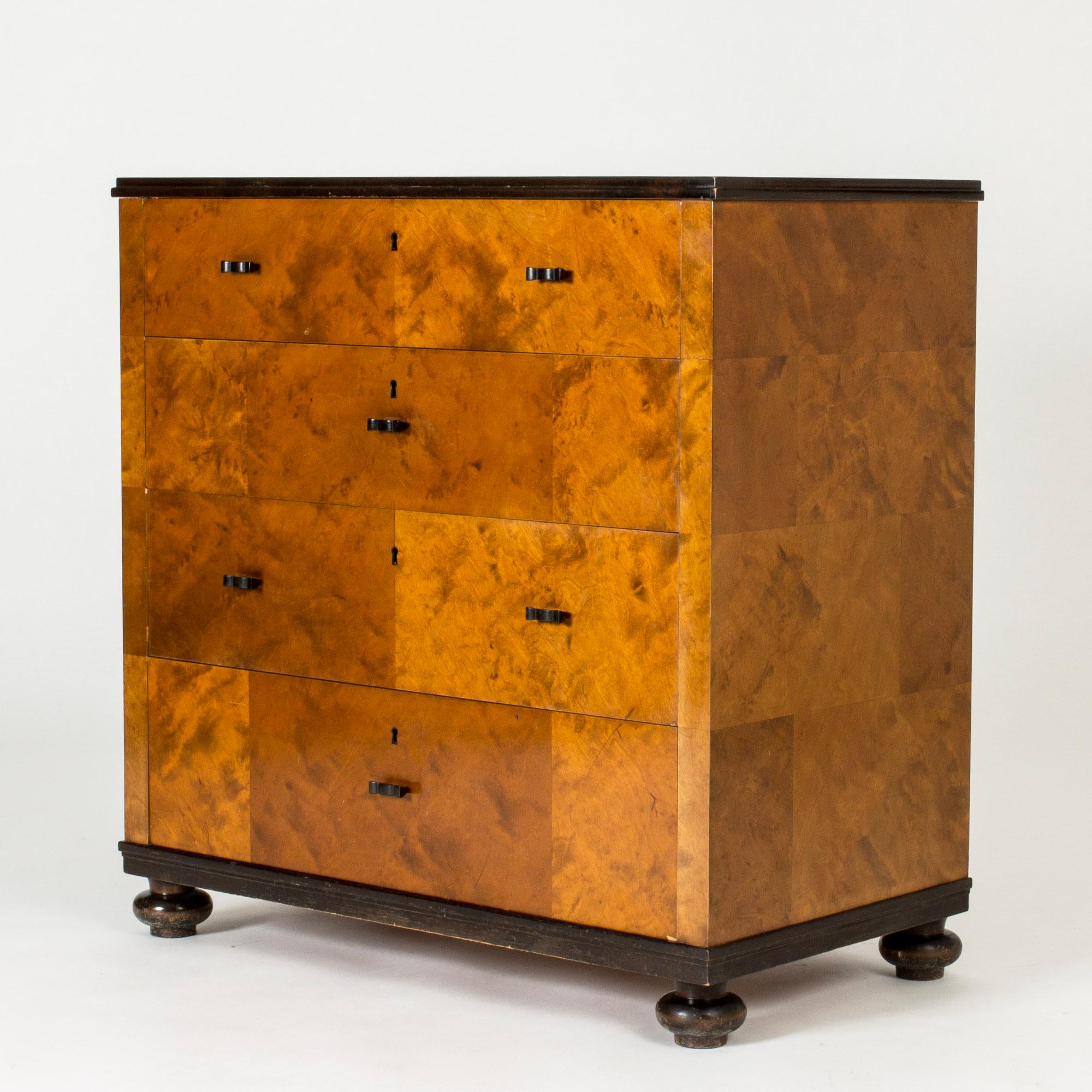 Elegant “Haga” chest of drawers by Carl Malmsten, made with stained birch veneer laid in a discreet pattern. Black painted legs and table top. Adorable handles in the form of crowns.
