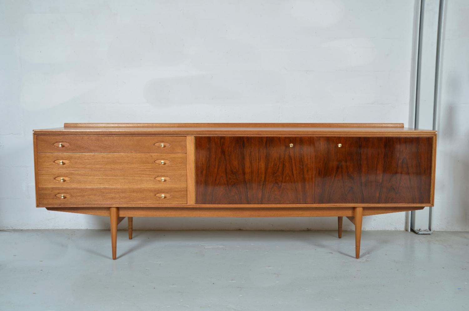 This elegant, extra long “Hamilton” sideboard was designed in 1958 by Robert Heritage for Archie Shine as part of the ‘Hamilton’ Rosewood series, which won a Design Centre Award. Robert Heritage is synonymous with great British design, and