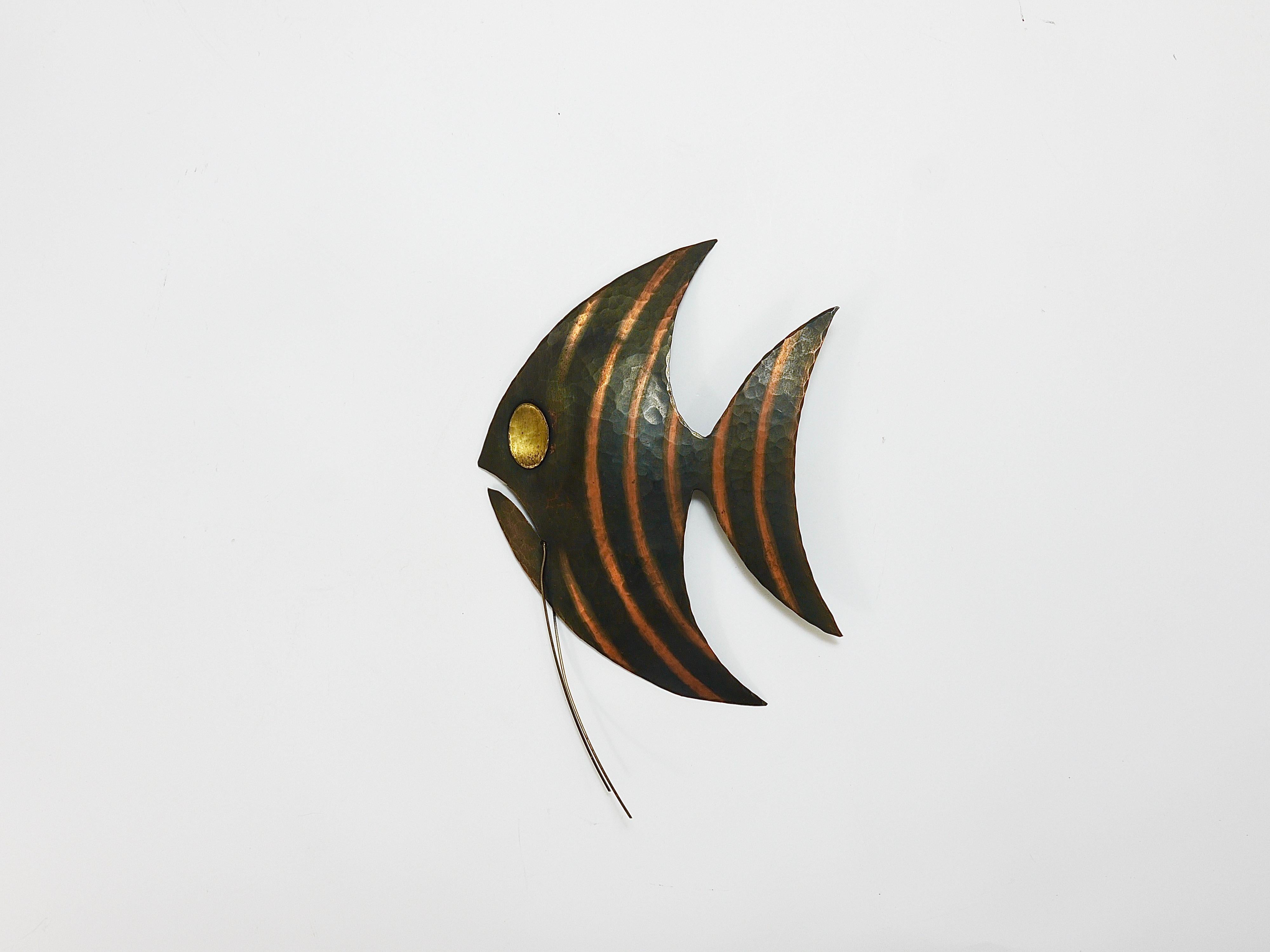 A charming and decorative striped Angel Fish wall-mounted sculpture from the 1950s. Handcrafted and hammer-blown of copper and brass. In excellent condition. Made in Austria. In the style of Walter Bosse / Werkstätte Hagenauer.
