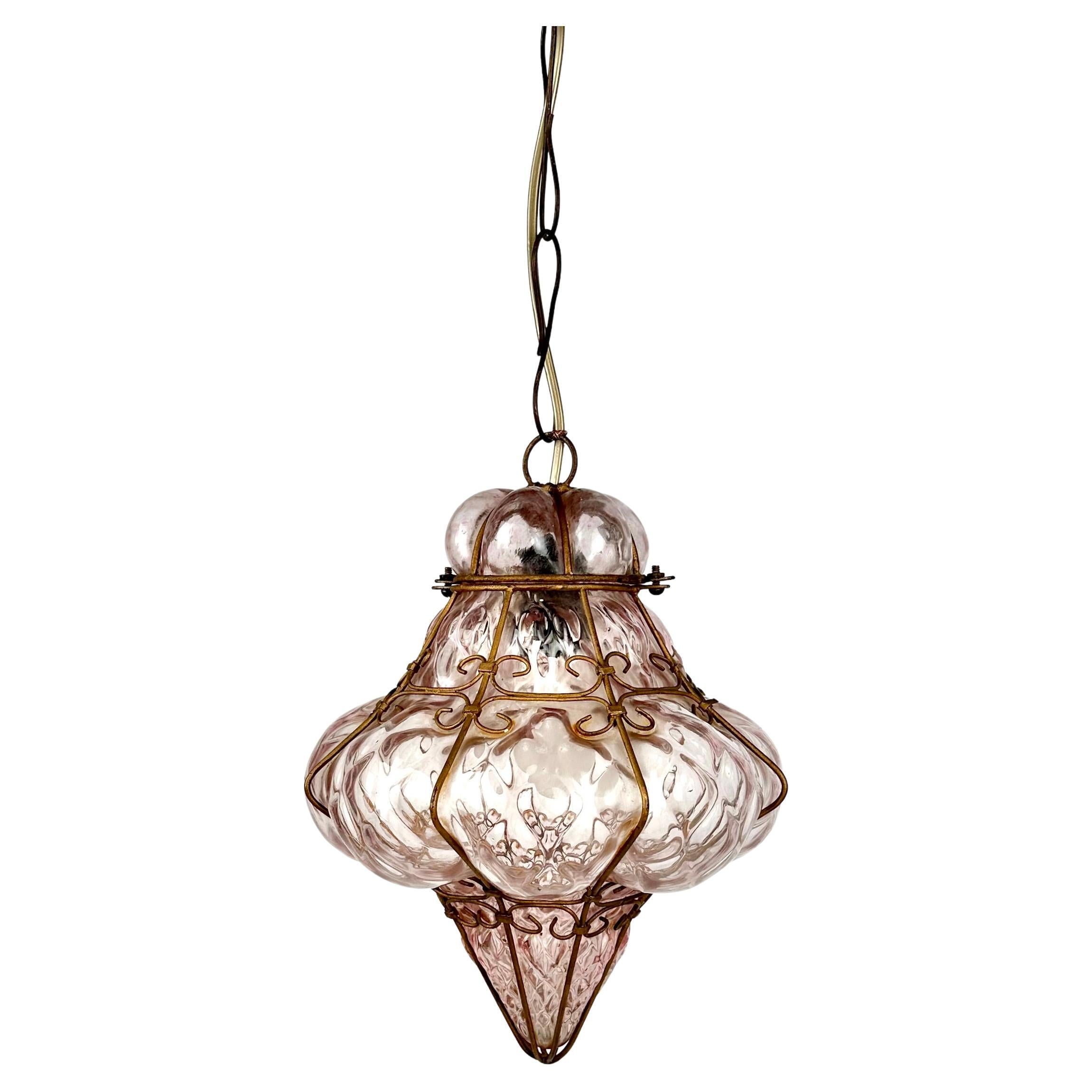 Magnifique suspension du milieu du siècle en verre soufflé à la bouche de Murano de couleur rose, entouré d'une cage en métal doré, réalisée par le maître souffleur de verre vénitien Seguso.

Fabriqué en Italie dans les années 1940.

Parfait pour