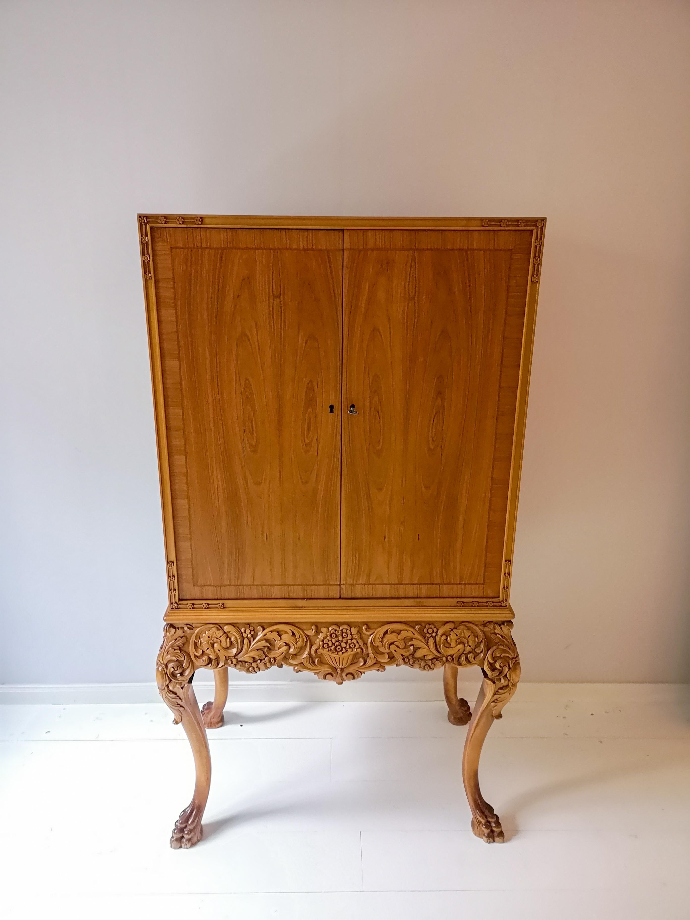 This wonderful handcrafted cabinet is made from elm veneer. Excellent carved and curved legs as well as wonderfully veneer that gives this cabinet a luxury’s feeling.

Good vintage condition. 

Measures: H 150, W 79, D 44 cm.
     