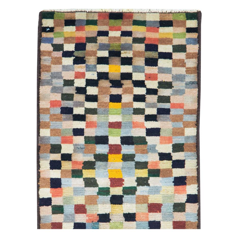 Chemin de table Persan Mahal vintage dans un style Art Déco moderne, fabriqué à la main au milieu du 20e siècle, avec un motif de damier dans une palette multicolore.

Mesures : 1' 7