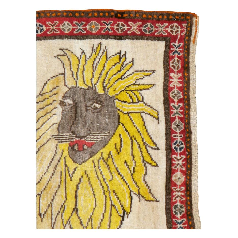 A vintage Persian Gabbeh folk rug with a pictorial depiction of an eccentric lion handmade during the mid-20th century by a nomadic tribe in Persia. The pale yellow body of the lion abrashes (natural color variation) to a brighter yellow in its mane