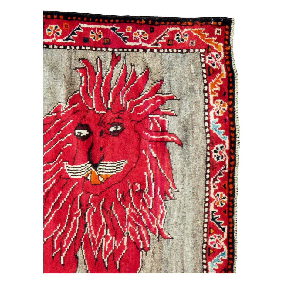 A vintage Persian Gabbeh folk rug with a pictorial depiction of an eccentric lion handmade during the late 20th century by the nomadic Qashqai Tribe in Persia. The entire lion is colored in red except for a few detailed outlines in ivory and brown,