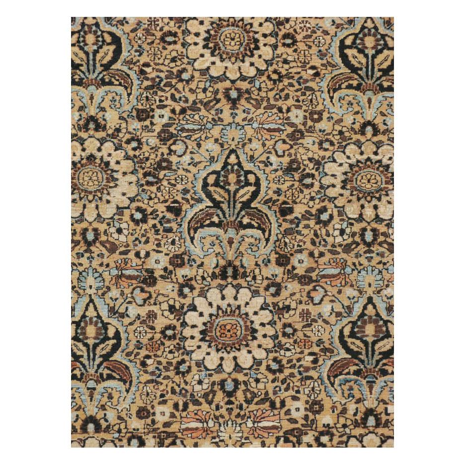 A vintage Persian Mashad room size area rug handmade during the mid-20th century with a oneway unidirectional all-over pattern in primarily light brown and light blue and secondary tones in black and coral.