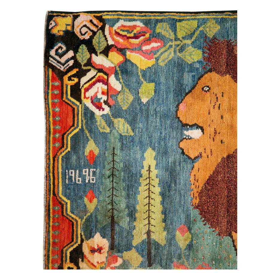 A vintage Caucasian Karabagh pictorial accent rug handmade during the mid-20th century. A male lion looks left over a cerulean blue and seafoam green polka dot field that encompasses two large cypress trees and large scale European floral