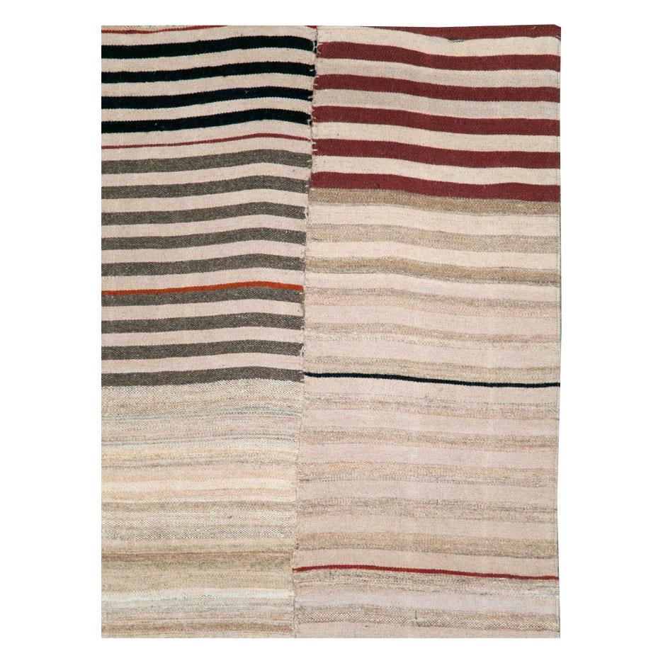 A vintage Persian Kilim flat-weave rug in gallery format handmade during the mid-20th century with 4 offset columns in beige, sienna, black, and nude.

Measures: 5' 7