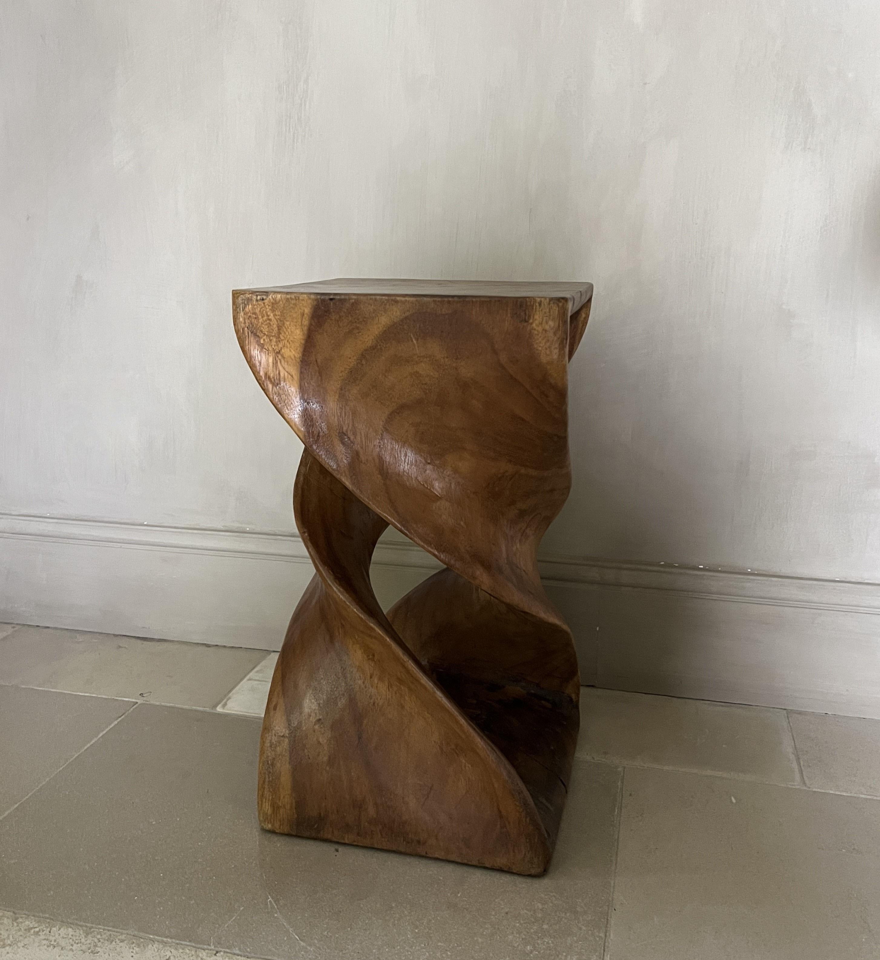 A stool or sidetable made from one single block of massive sexotic wood. Verry much reminiscent of midcentury modernist desigerers like Brazilian architect Zanine Caldas. The handsculpted ellipse shape gives this stool an impression of lightness and