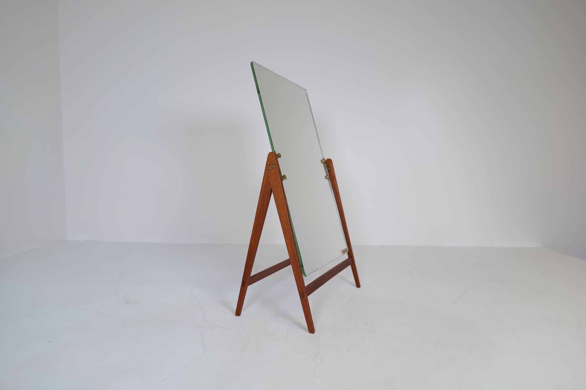 This rare mid-century table mirror in brass and teak was produced in Sweden at AB Markaryd and designed by Hans-Agne Jakobsson. The mirror stands on a teak foundation and has a swinging mode to be able to adjust the position. The brass details and