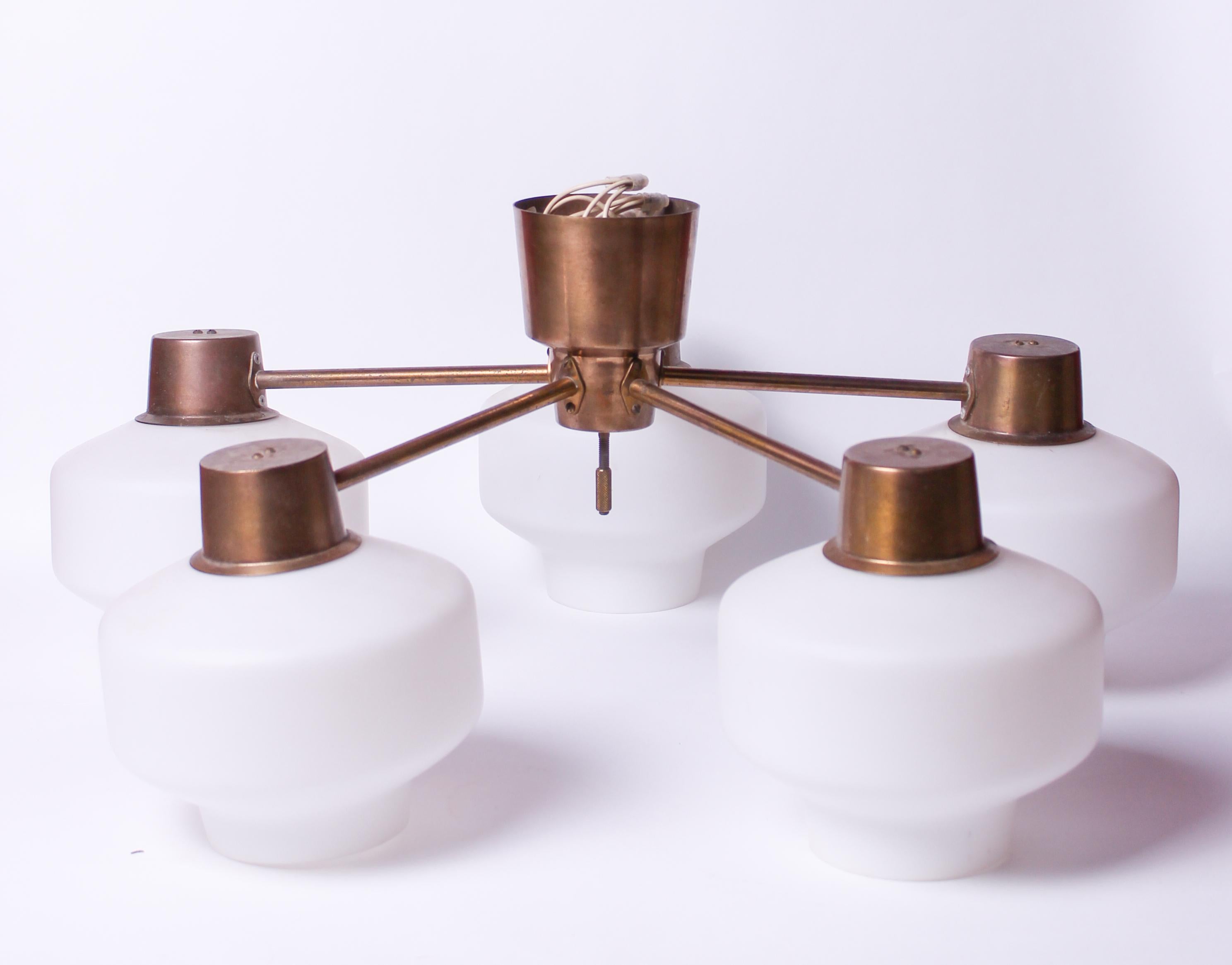 A midcentury Hans Bergström ceiling lamp by Hans Bergström produced by the Swedish company ASEA. The lamp has five arms with shades mad out of opaline glass. The brass has a nice patina consistent with age. 

Very good vintage condition.