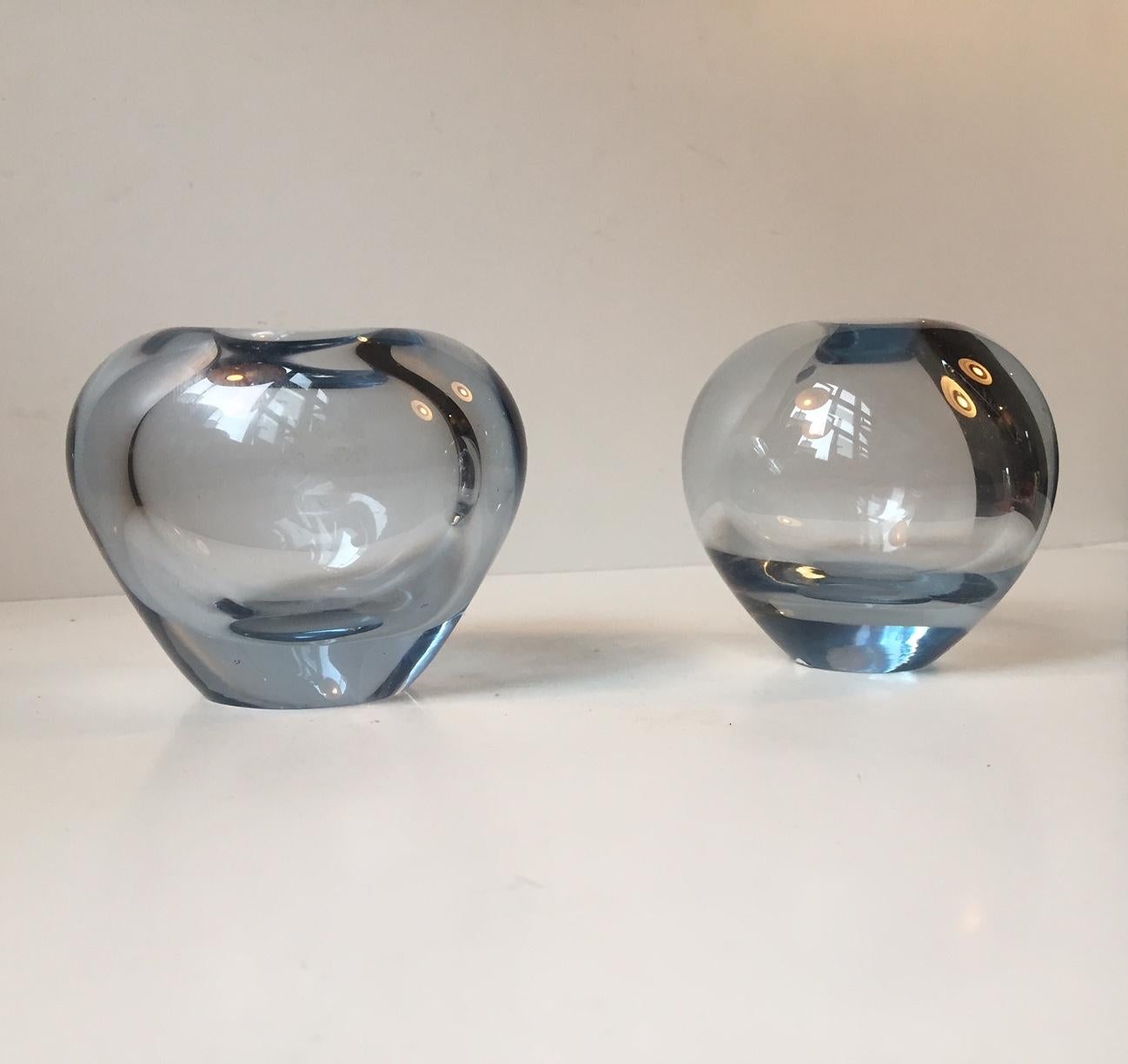 Blue tinted vases by Danish glass blower Per Lütken. They are called the 'Heart and Ball' vases. Both are signed by hand by the maker and designer (PL) to the bottom and dated 1960 and 1962. The height of the smaller vase is 8 cm.