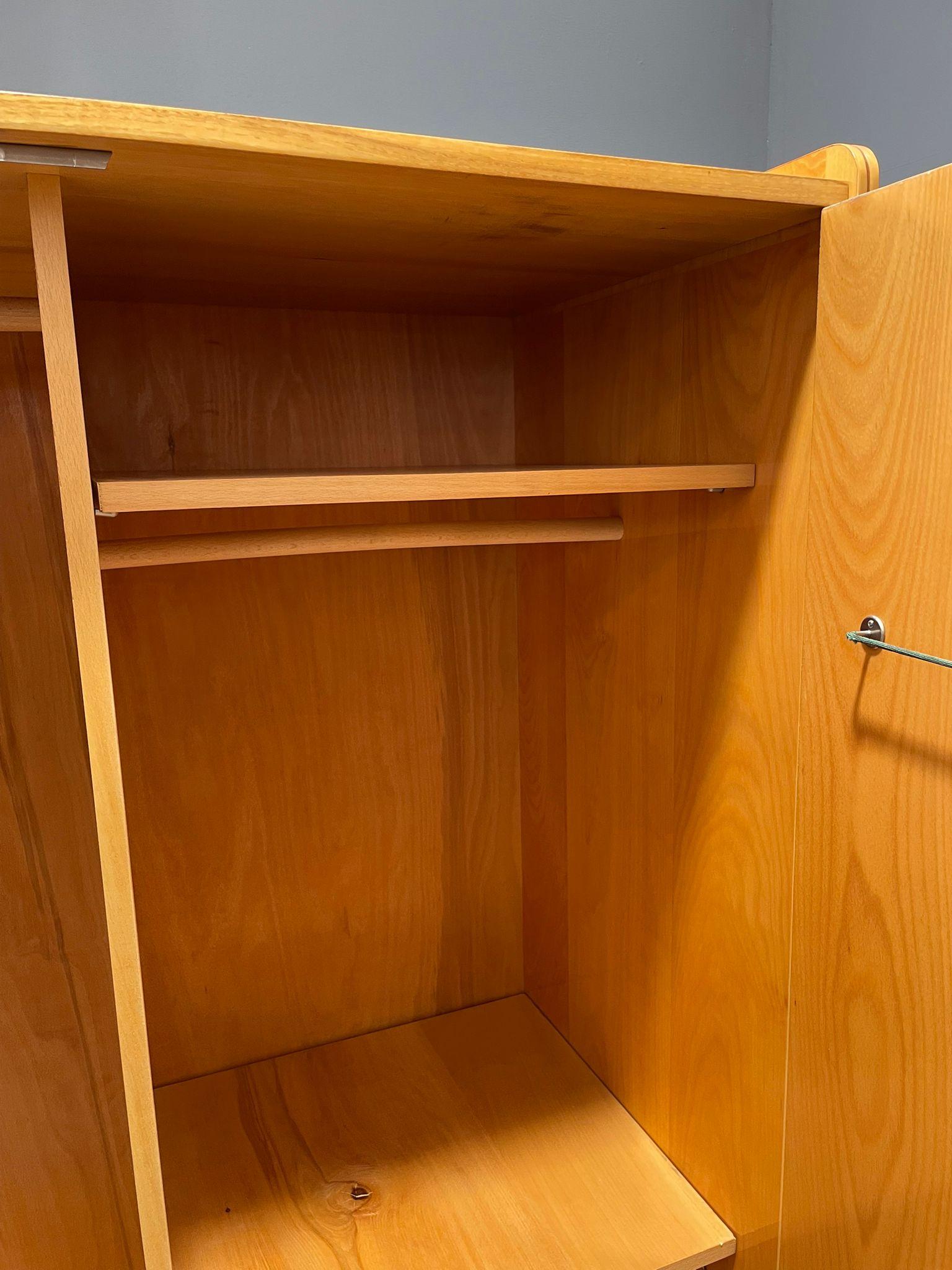 Dieser zweitürige Schrank wurde von Tatra Nábytok in der ehemaligen Tschechoslowakei in der Mitte des 20. Jahrhunderts (1930er-1960er Jahre) hergestellt. Es ist Teil einer breiteren Möbellinie, die im Einfluss des Art déco wurzelt und typisch für