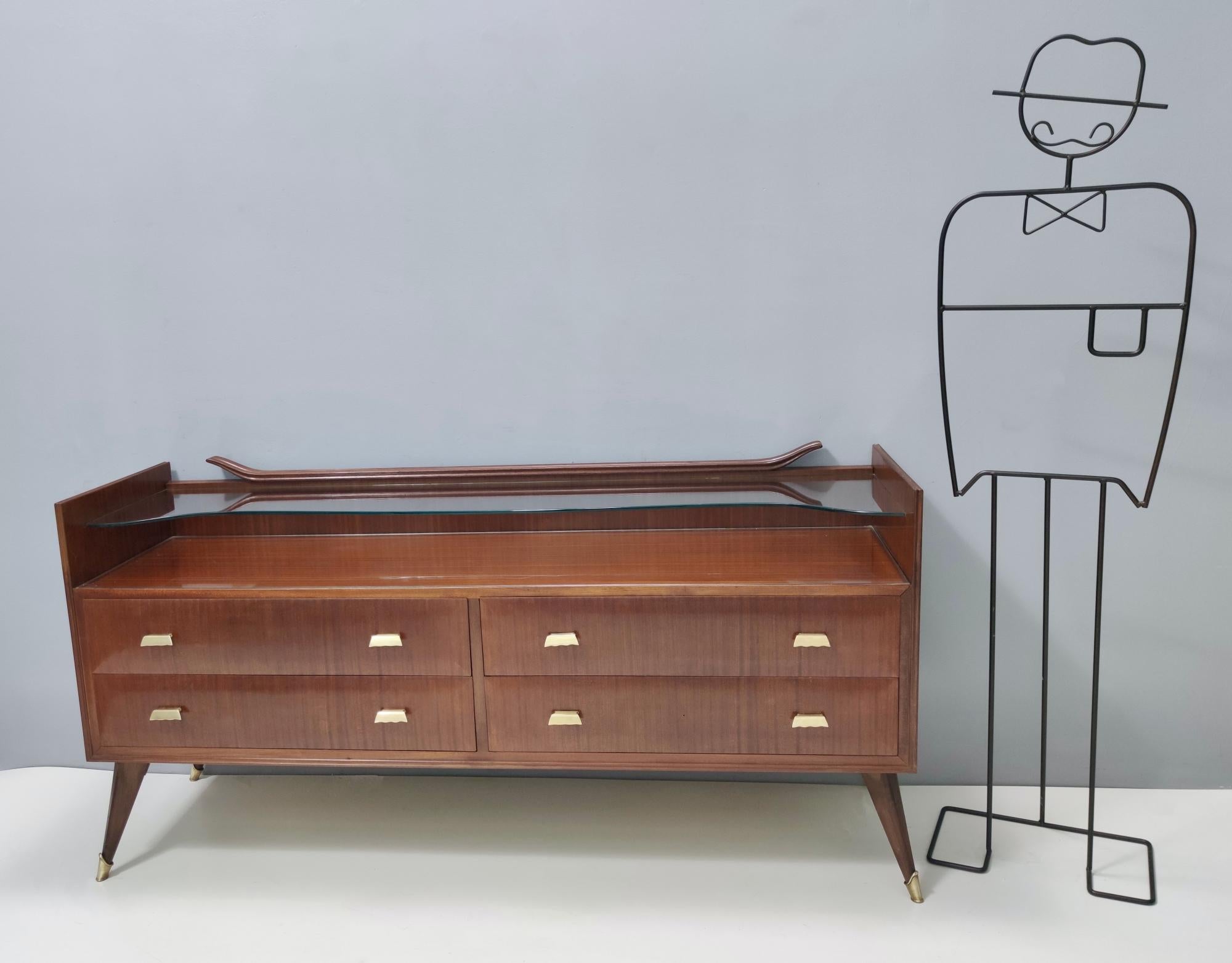 Made in Italy, 1950s. 
This is a high-quality dresser that is made in walnut and features a quite thick glass top and brass handles and feet caps.
It is a vintage piece, therefore it might show slight traces of use, but it can be considered as in