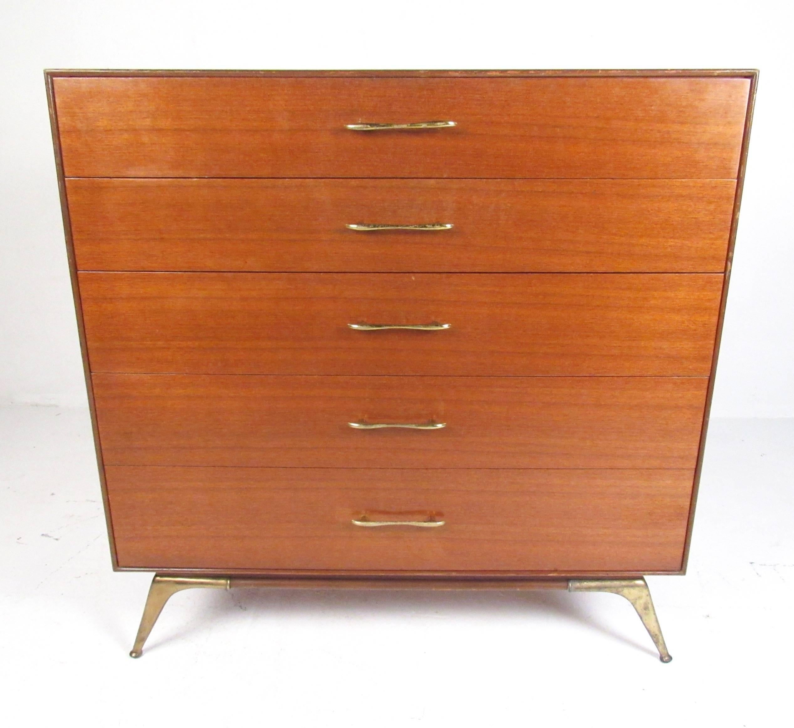 This quality midcentury dresser by R-Way furniture features retro modern design and spacious storage drawers. Stylish brass drawer pulls add to the vintage appeal of this light colored wood finished highboy dresser. Ideal dresser for any interior,