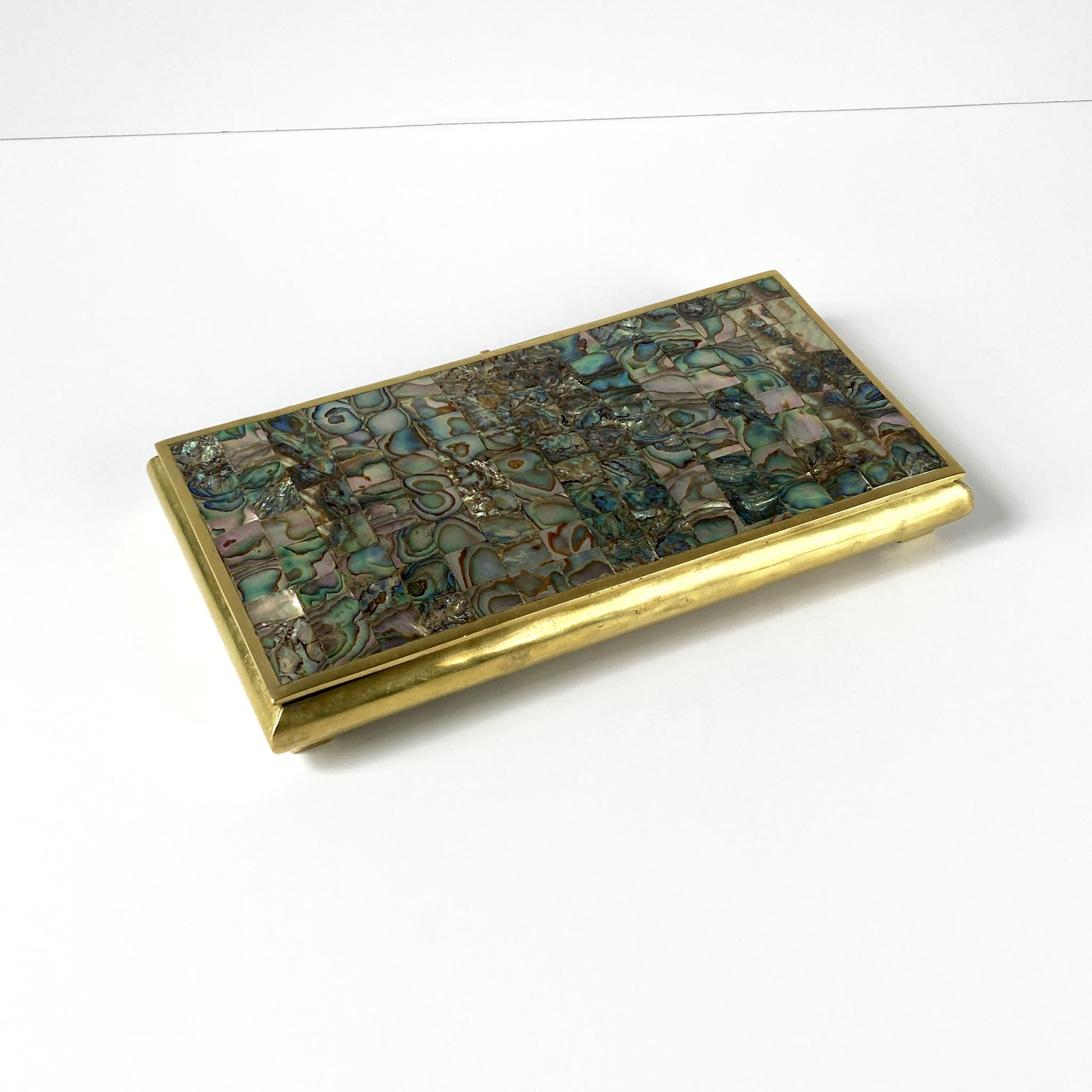 Beautiful hinged brass box with abalone mosaic on lid, wood-lined. The pattern of the mosaic contrasts beautifully with the brass; the iridescence of the abalone is luminous in shades of green, tan and pink. This piece looks great as part of a