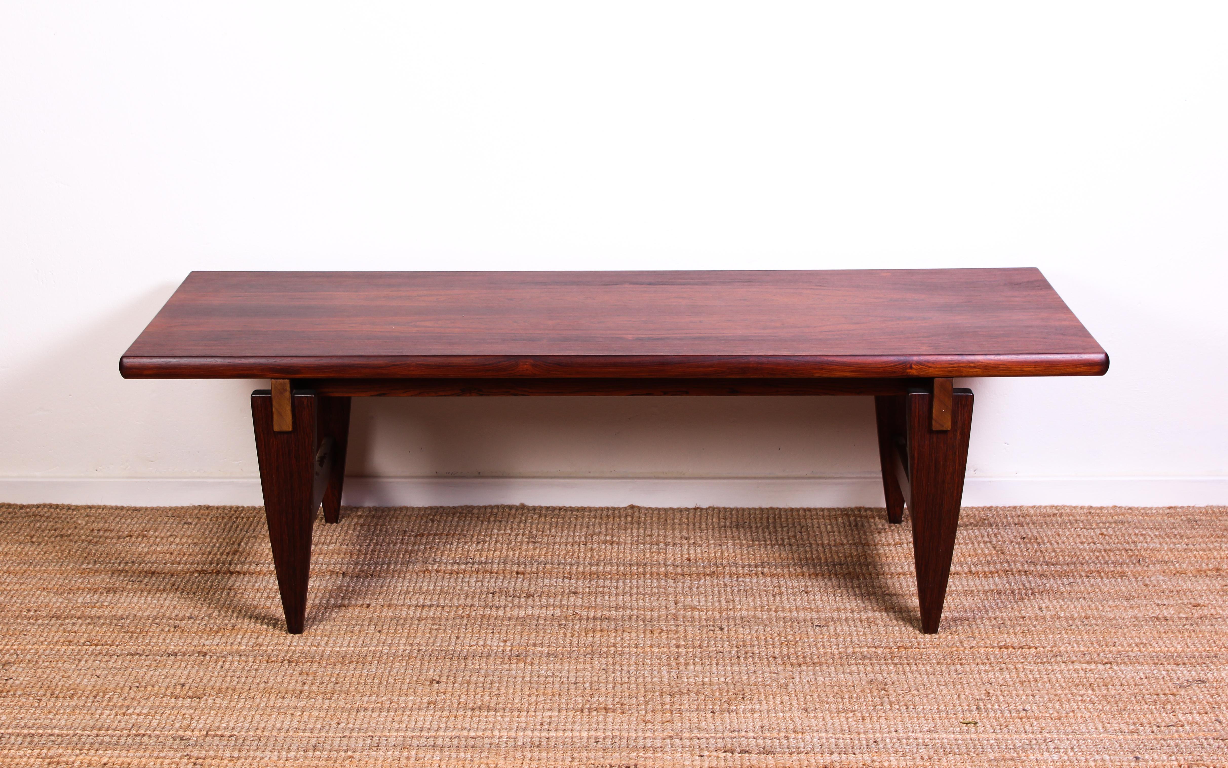 This Mid-Century Modern coffee table made out of rosewood is designed by Danish designer Illum Wikkelsø. The table has been professionally refinished and is in excellent condition. The design combines modern and Brutalist design which makes this a