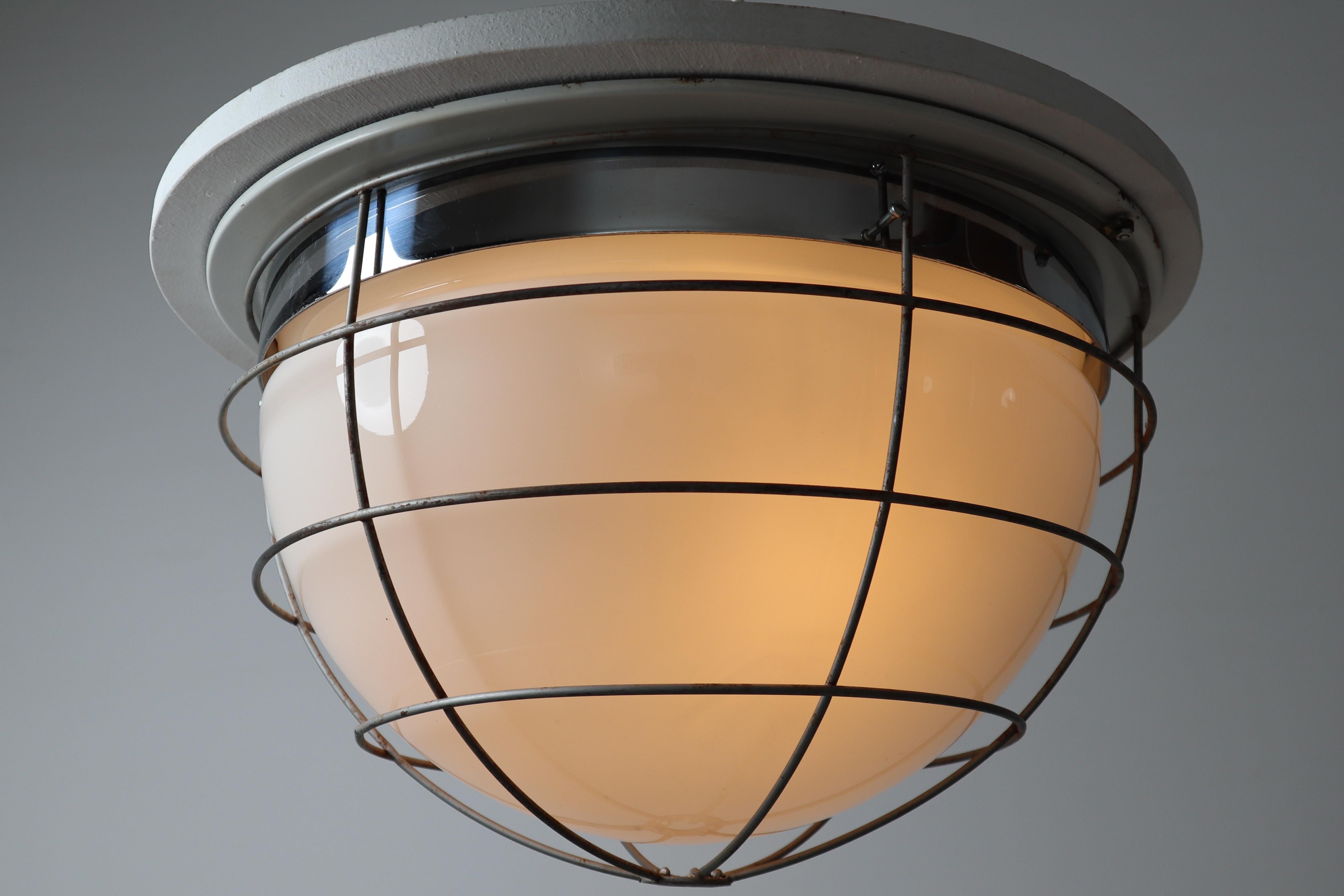 Midcentury Industrial ceiling light or wall scones with steel frame lacquered fitted with two E27 bulbs up to 100W and with opaline glass shade and a protection grid. Europe, 1960s. Very good condition with nice patina on steel parts.

Please note