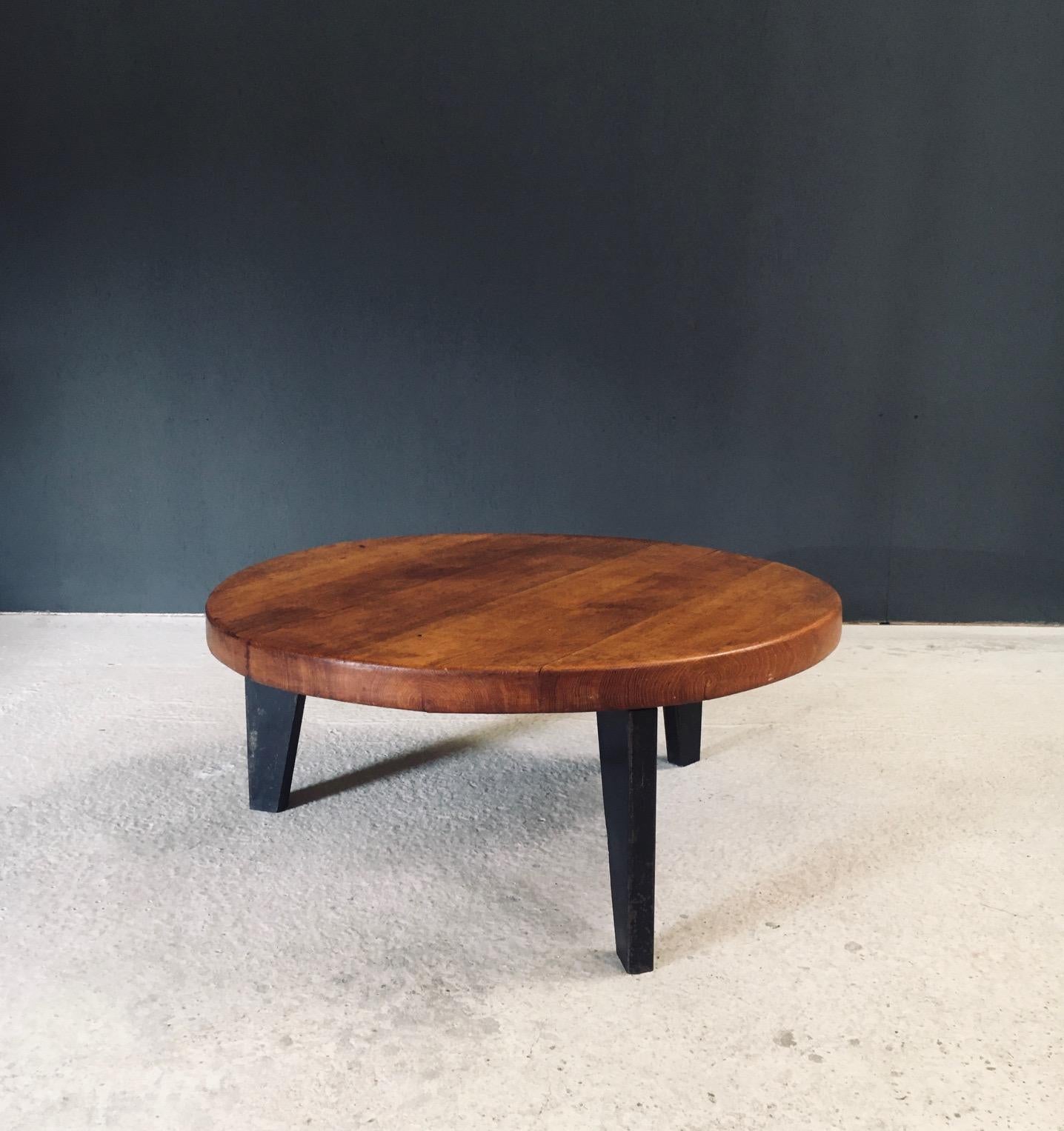 Runder Couchtisch im französischen Industriedesign der Jahrhundertmitte im Stil der Entwürfe von Jean Prouvé. Hergestellt in Frankreich, 1950er Jahre. Der Tisch besteht aus einem dreibeinigen Metallfuß und einer massiven Eichenplatte. Sie sind