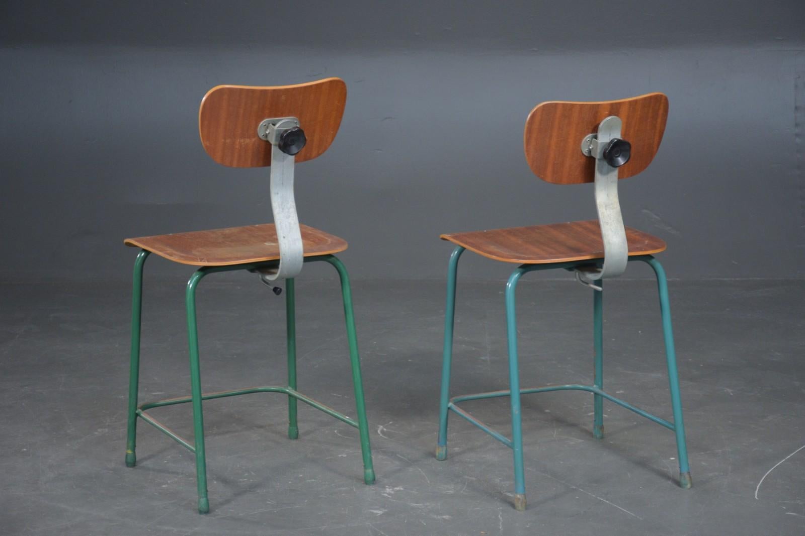 Industrial chairs / work chairs. Seat and back of veneered teak, frame and legs of green lacquered steel. Adjustable back, 1950-1960, H. 82 cm. Seat height 49 cm. Traces of wear, scratches, peeling and rust. Set of two.