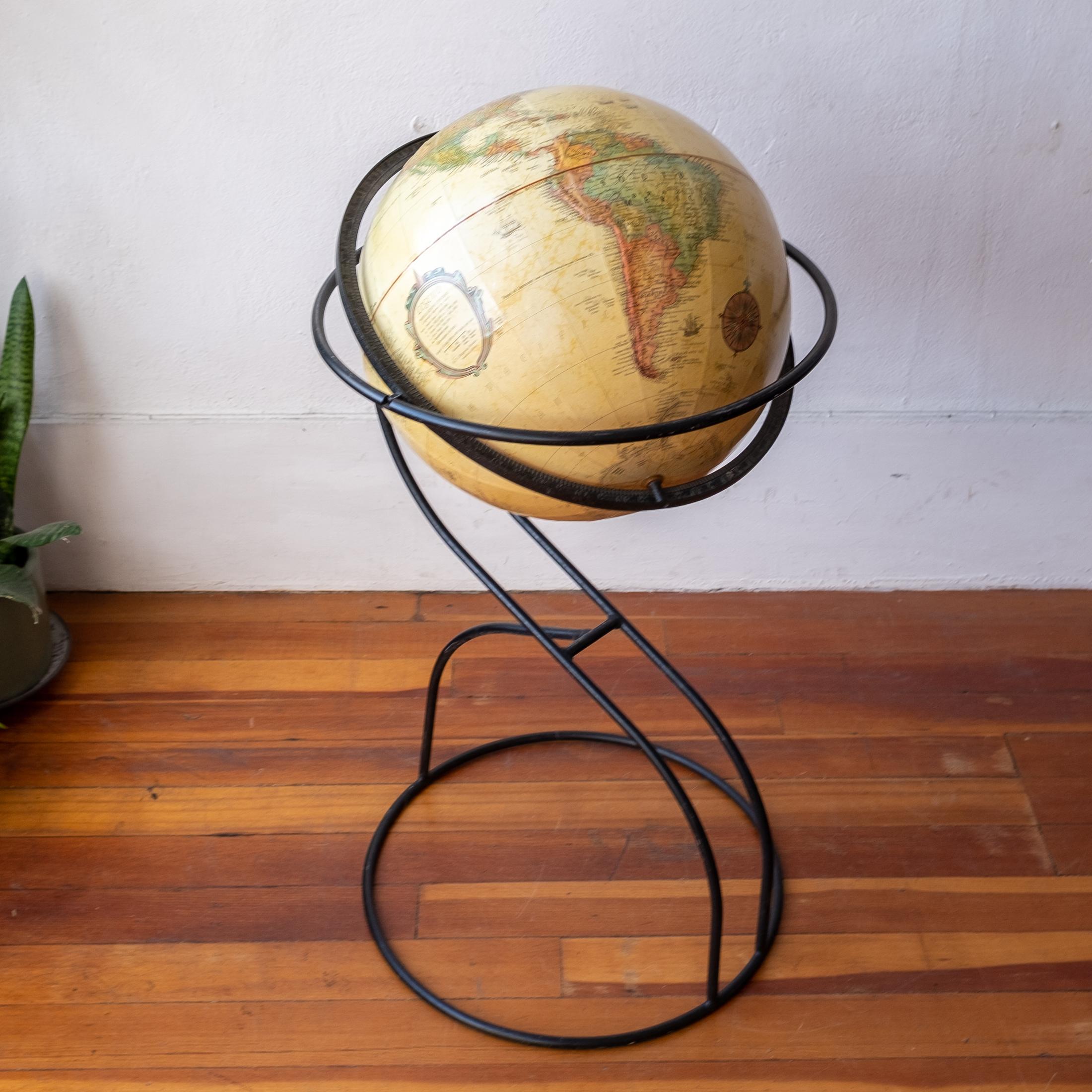 Midcentury standing globe from the 1960s. The topographical globe dates from the 1960s. Amazing sculptural iron floor stand. The globe spins and rotates and includes longitude and latitude lines. 
 