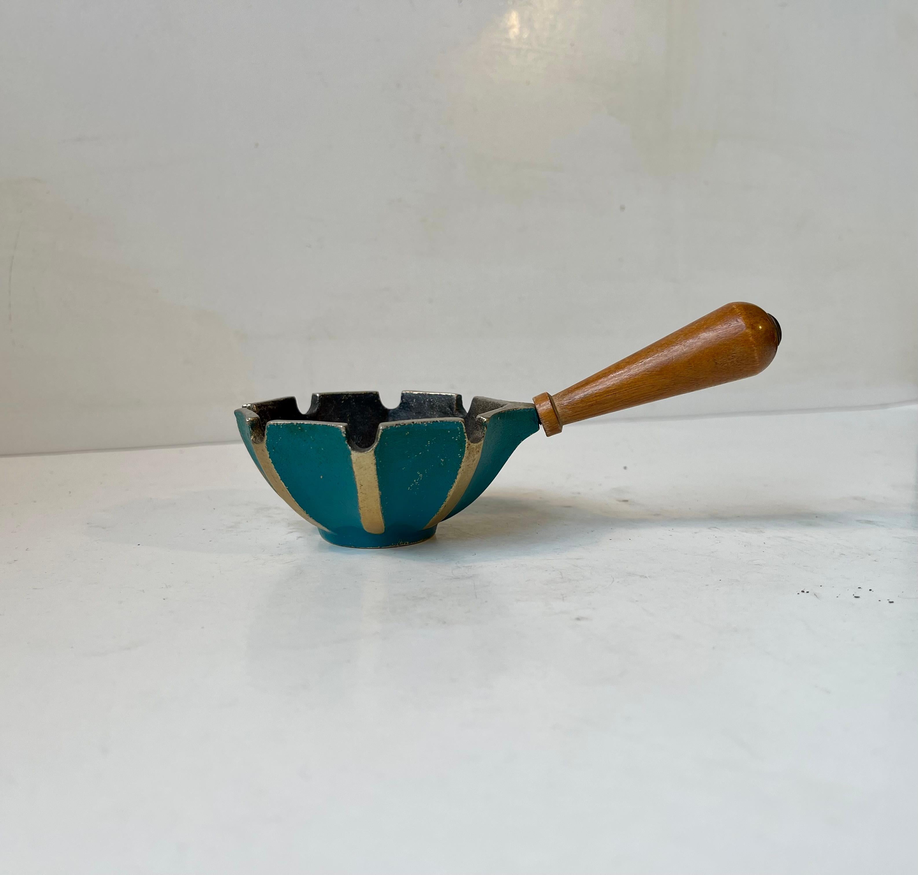 Ein praktischer Aschenbecher mit Griff. Er ist aus Buche und geriffeltem Gusseisen gefertigt und teilweise mit blaugrüner Farbe verziert. Hergestellt in Israel, ca. 1960-70. Abmessungen: B: 15/8 cm, H: 4 cm (Schale). Werden Sie grün mit
