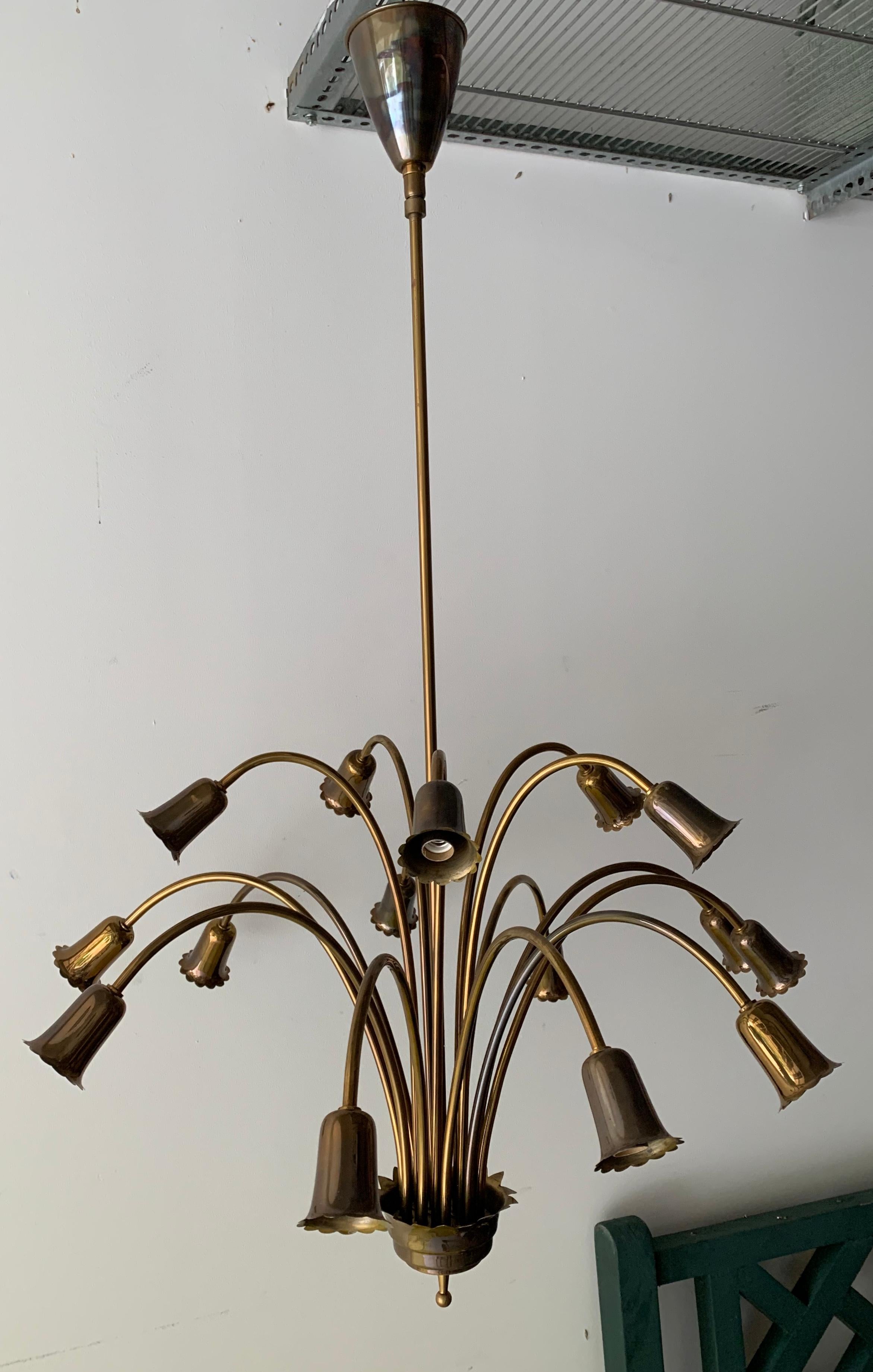 A period midcentury brass chandelier with 15 arms. 

In the style of Stilnovo.

Beautiful dark brass patina.

Measures: Total drop height, 27.5 inches
Height without stem/canopy, 18 inches
Width, 26 inches.