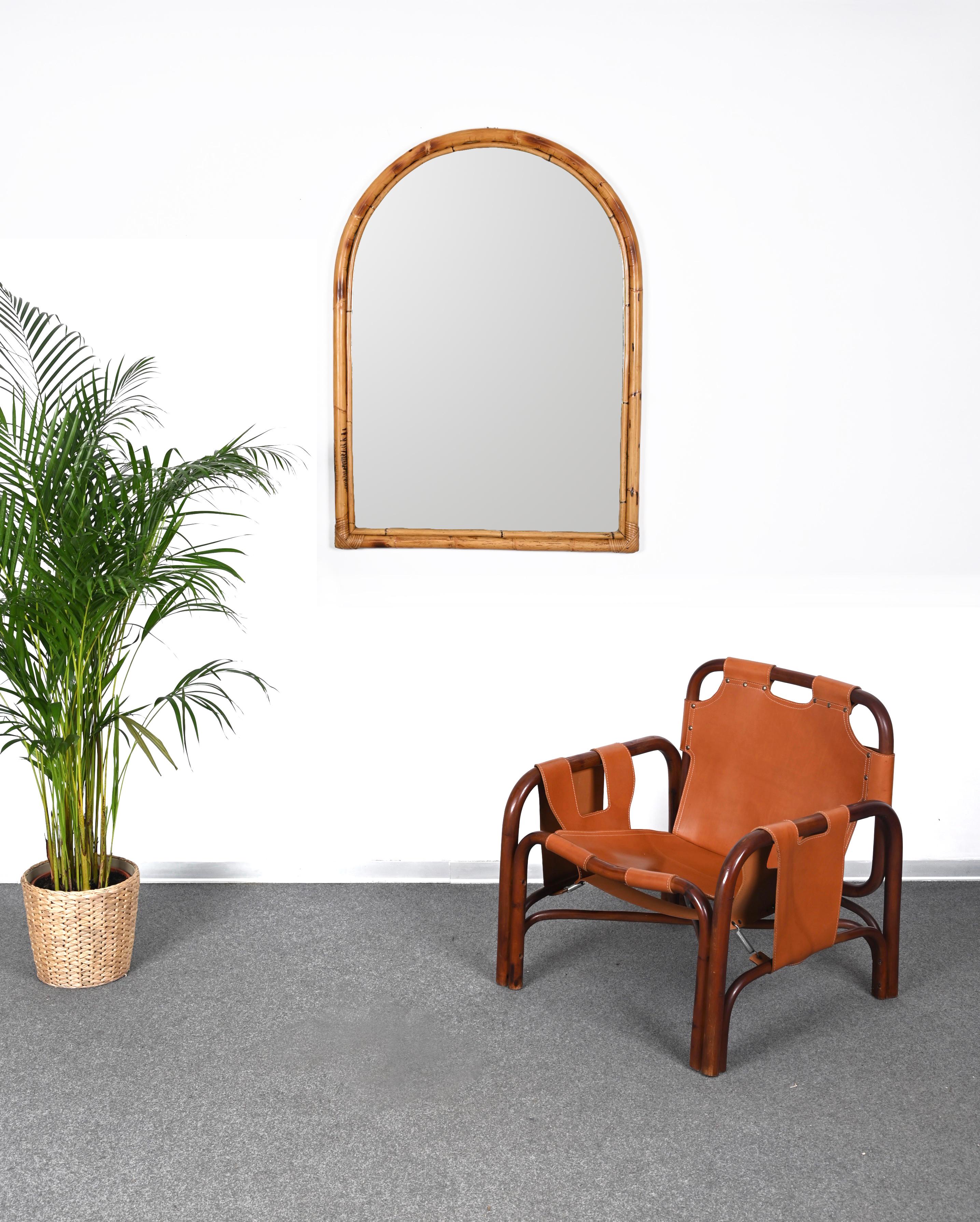 Wonderful large midcentury arched mirror with double bamboo frame. This fantastic rare mirror was produced in Italy in the 1970s.

The way the two round bamboo lines and the glass integrate through the sinusoidal wickerwork is superb and gives