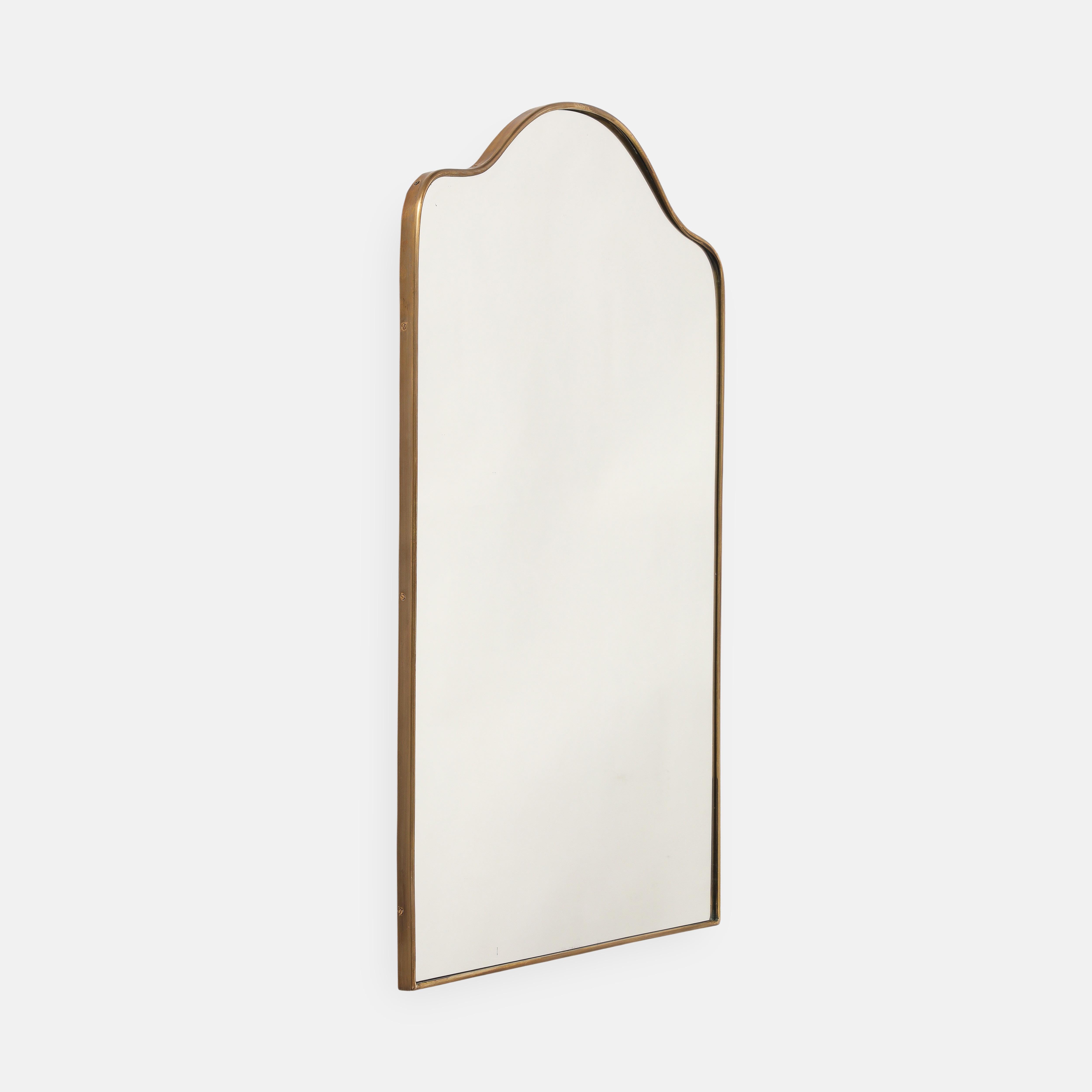 Miroir mural en laiton de style italien du milieu du siècle, de forme arquée, avec le haut légèrement incurvé et les côtés et le bas droits. Ce joli miroir chic est intemporel et s'adapte à tous les intérieurs, qu'ils soient classiques ou modernes.
