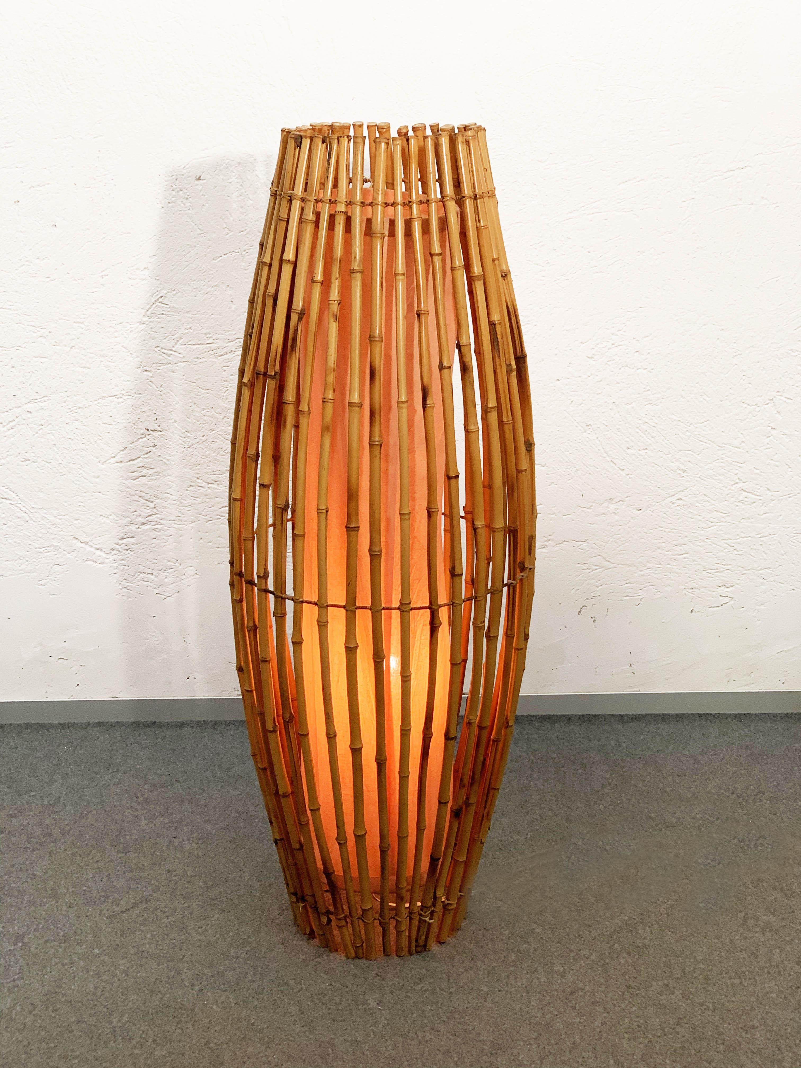 Magnificent and tall midcentury floor lamp. It is likely it is a Franco Albini production, designed in Italy during 1960s.

A rare example of how bamboo and rattan can magnify the refraction of the light, this item echoes tribal lines.

The lamp