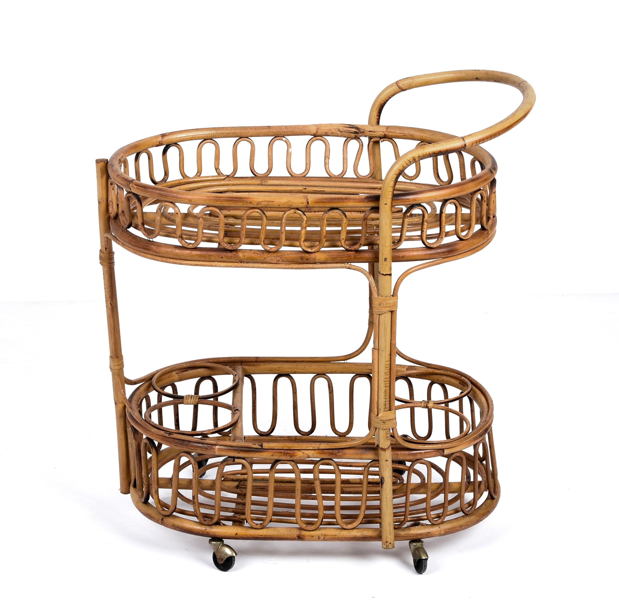 Fabulous midcentury two-tiers bar trolley in fantastic vintage conditions. This wonderful item was produced in Italy during the 1960s.

This fantastic piece has a bamboo structure and rattan floor bases, a lower-tier that is ideal for bottles with