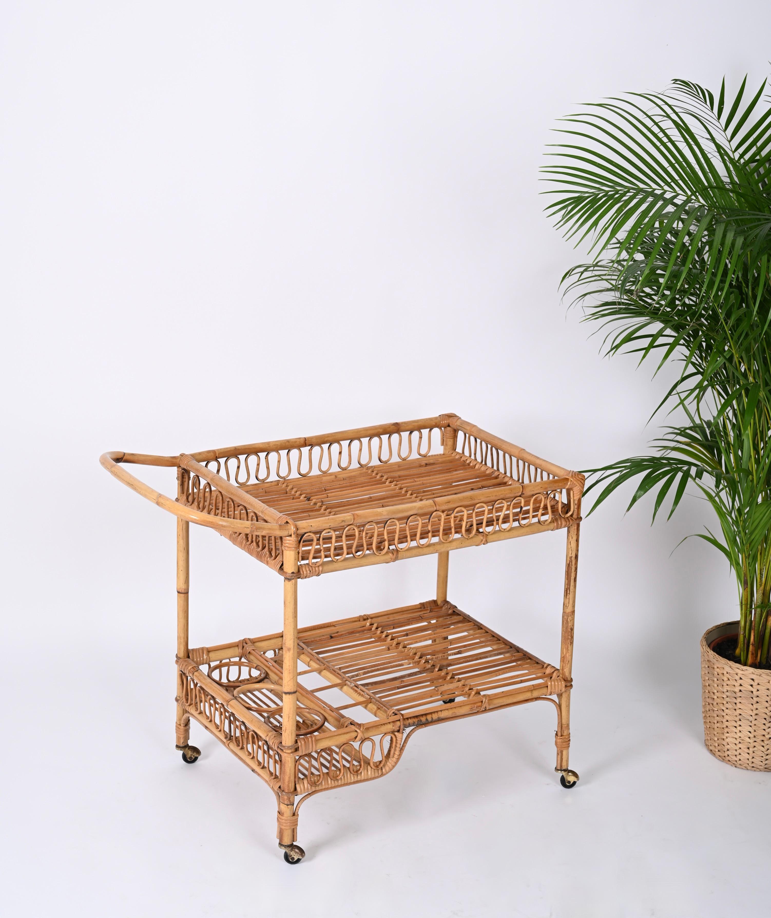 Marvellous mid-century rectangular bar cart trolley fully made in bamboo and curved rattan. This unique piece was hand-made with perfect proportions, great example of fine Italian craftsmanship from the 60s.

A wonderful piece with incredible