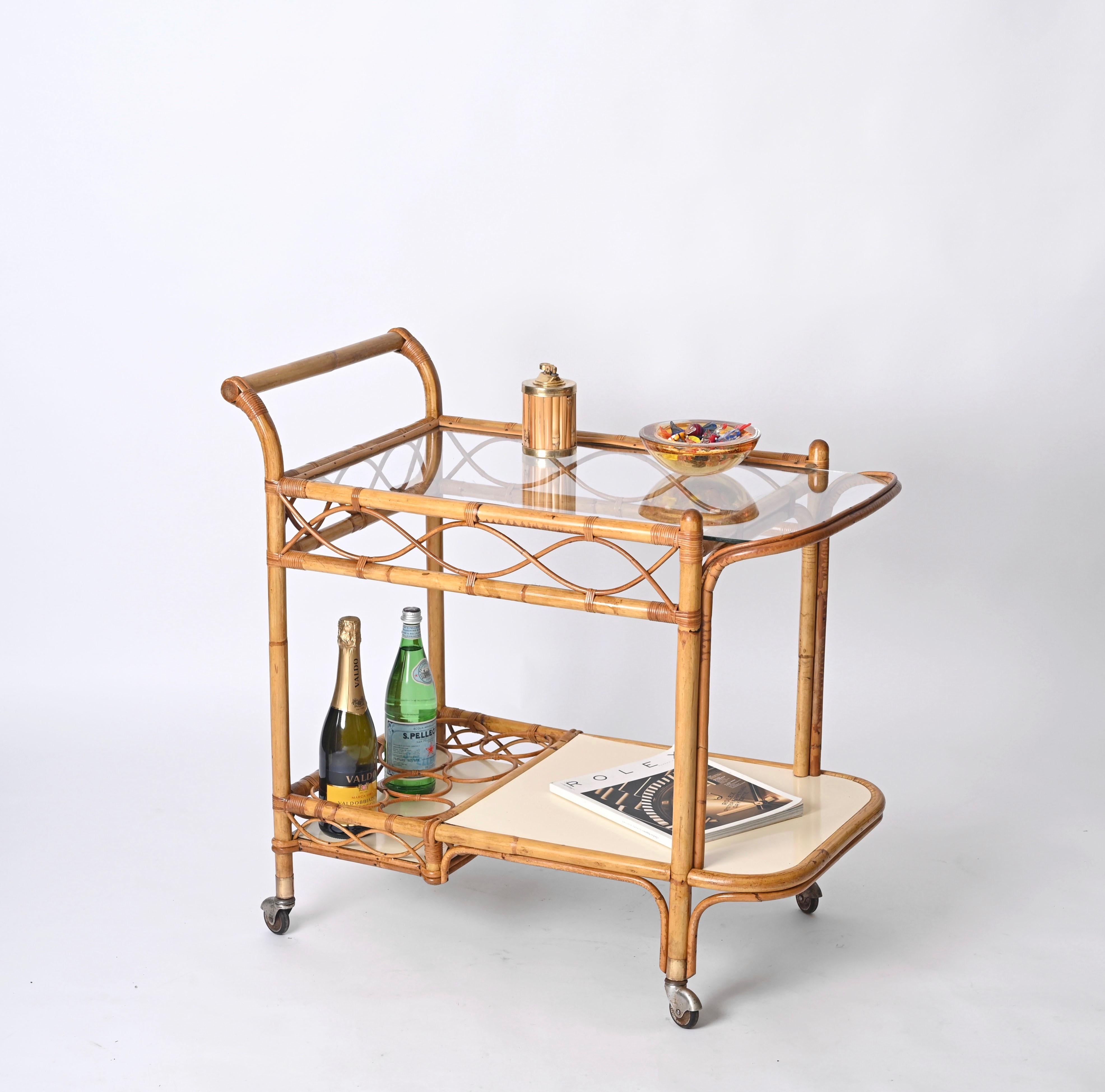 Gorgeous Mid-Century Italian serving trolley in bamboo, curved rattan and woven wicker and white formica. This exceptional piece was produced in Italy during the 1960s.

This unique bar cart has a structure made in bamboo enriched by stunning