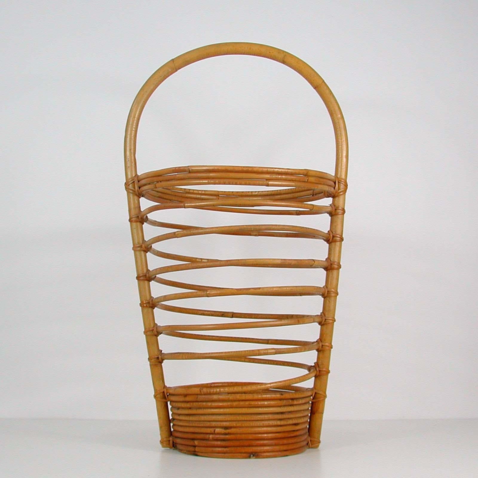 This beautiful loop umbrella stand was made in Italy in the 1960s. It is made of bamboo and wicker and has got a white ceramic bowl to the inside to catch the rain.