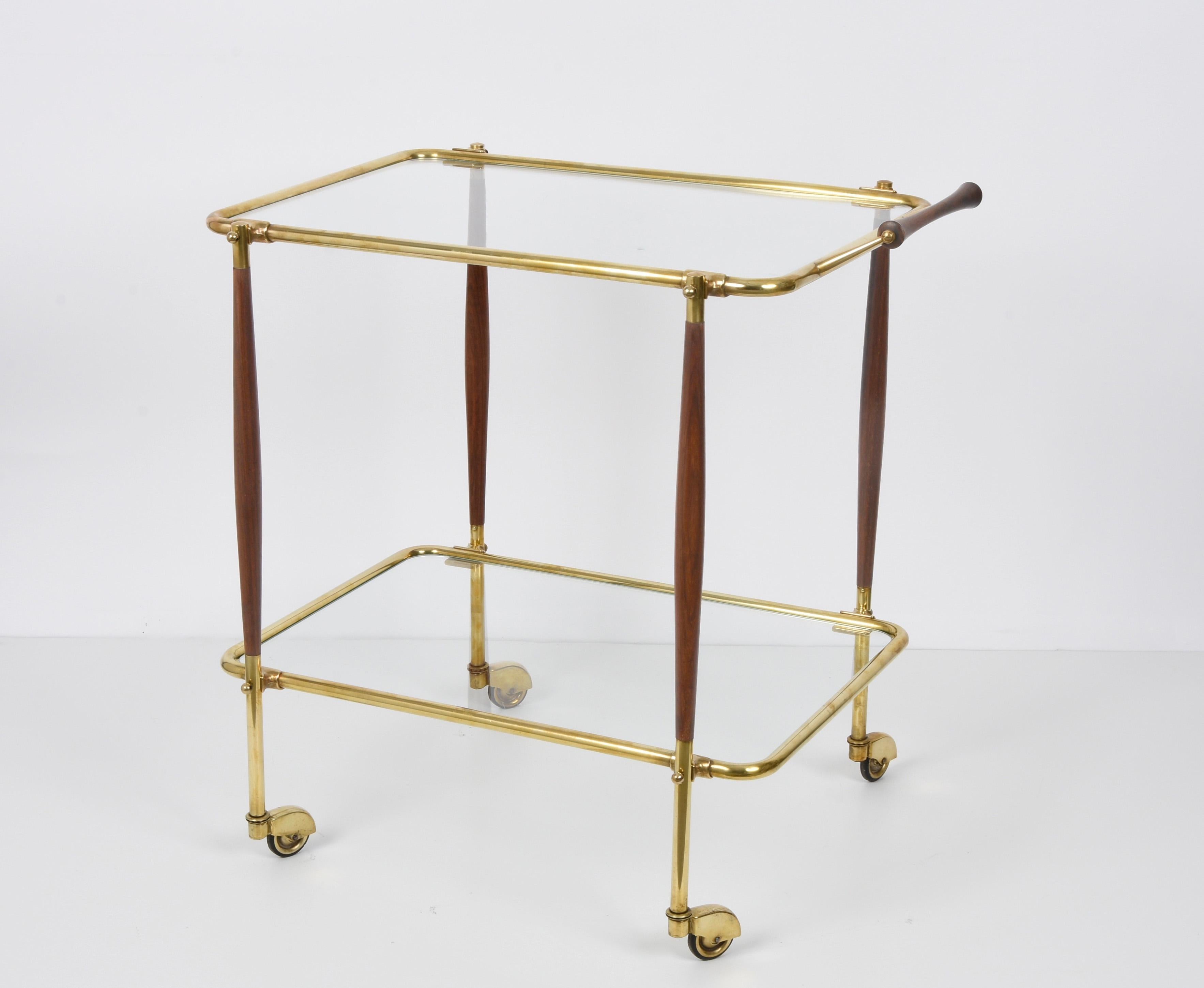 Amazing midcentury bar trolley designed in brass and wood. This fantastic piece was designed by Cesare Lacca during the 1950s.

This wonderful item has an elegant structure in brass with a central part in wood holding two internal glass shelves