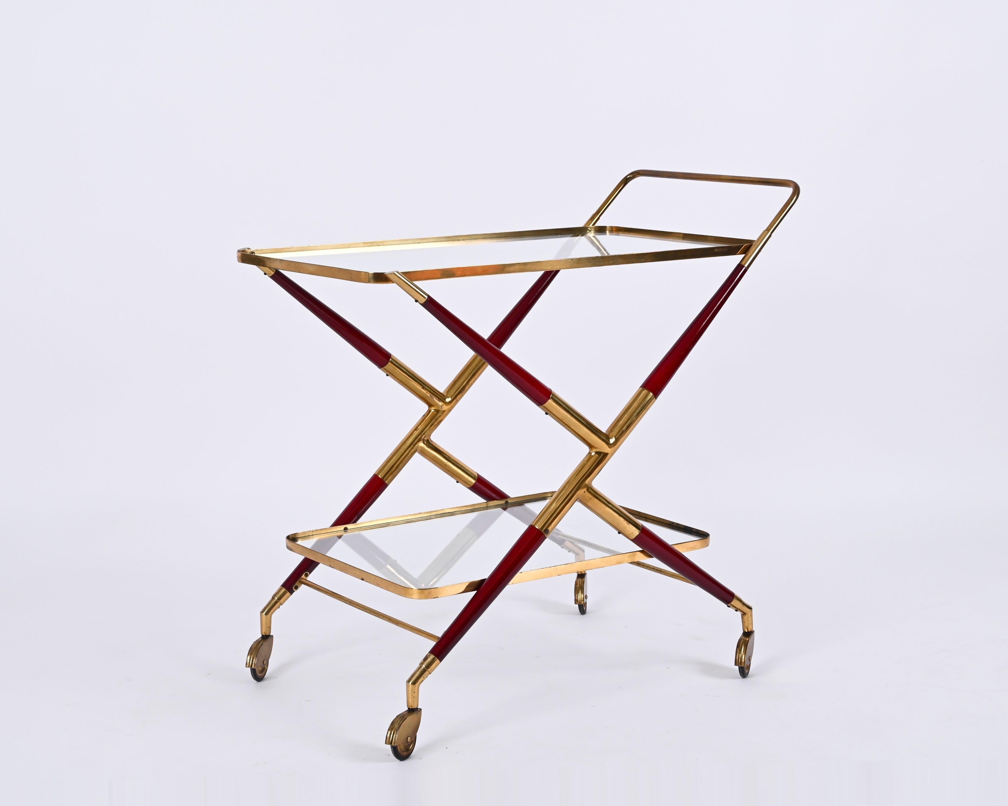 Marvellous Italian bar trolley in brass and burgundy red lacquered wood. This stunning piece was designed by Cesare Lacca in the 1950s in Italy. 

The cart is in its fully original configuration, it features an X-shaped structure in brass and a