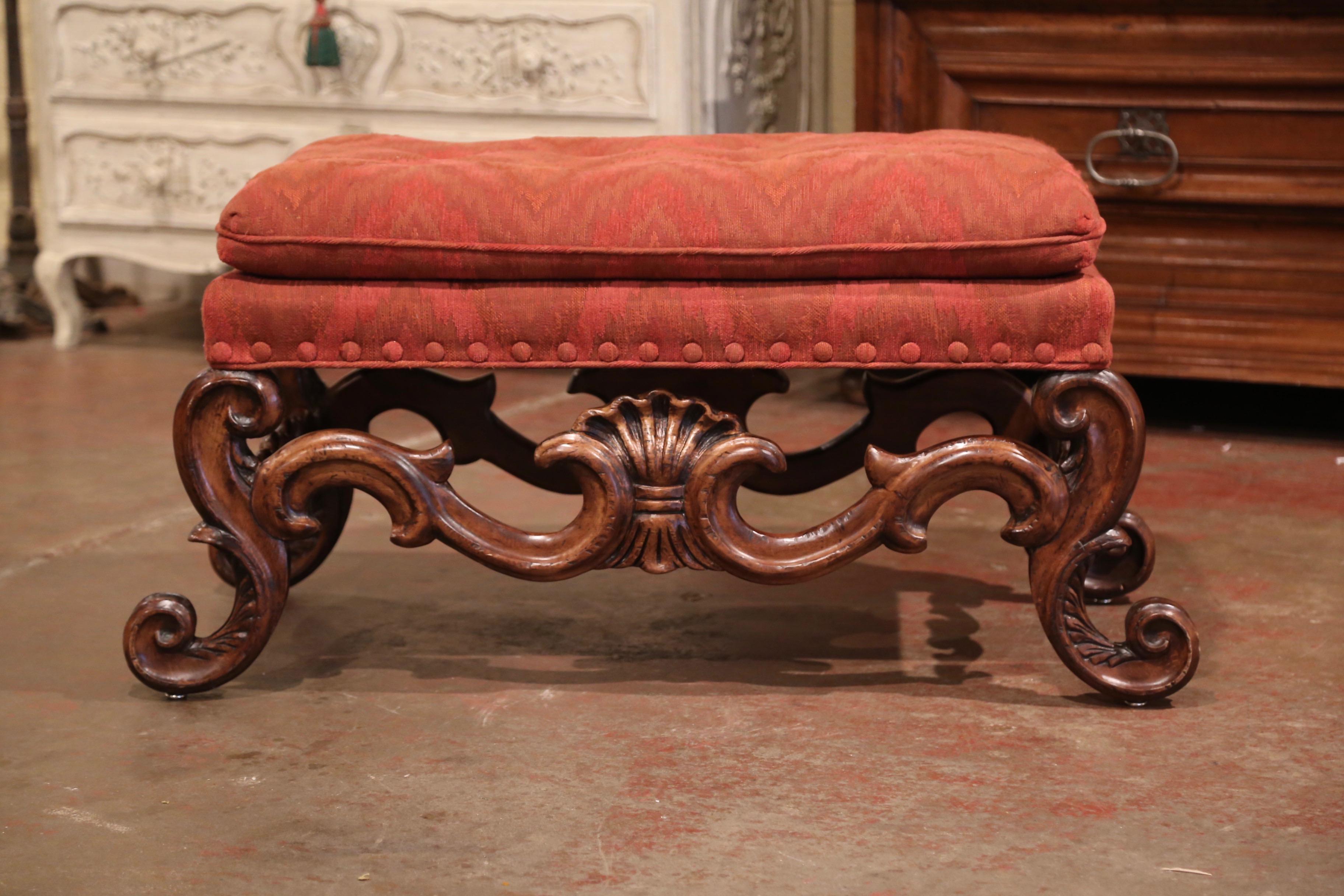 Bring extra seating in a den or a living room with this large and elegant ottoman; crafted in Italy, circa 1960, the fruitwood bench stands on scroll legs decorated with a large carved shell motif on the scalloped apron. The Baroque pouf is