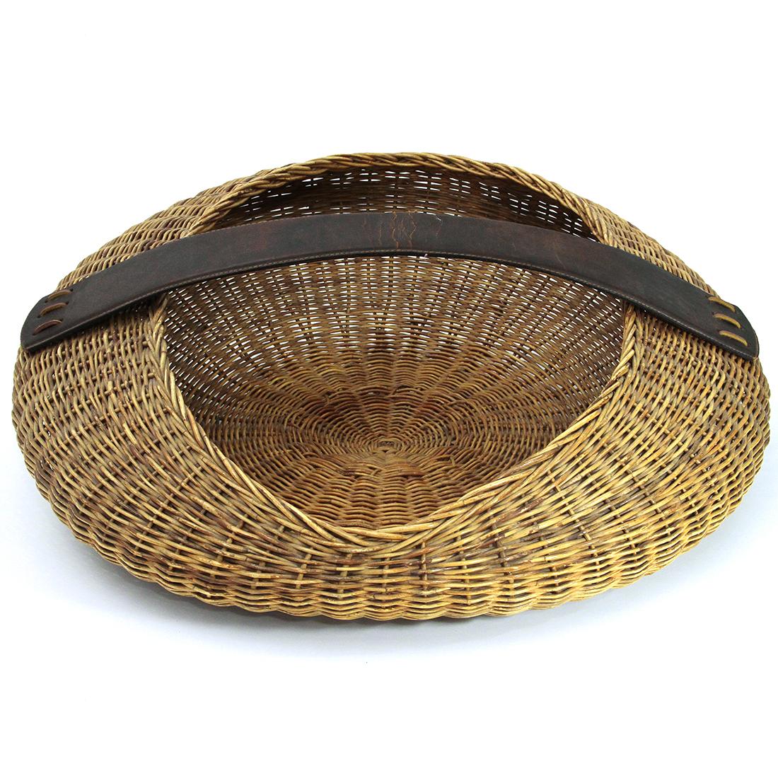 Wicker basket produced in the 1950s by Bonacina on a project by Tito Agnoli.
Circular structure in stuffed rattan with oval opening.
Large leather handle.
Structure in good condition, some signs due to normal use over time.

Dimensions:
