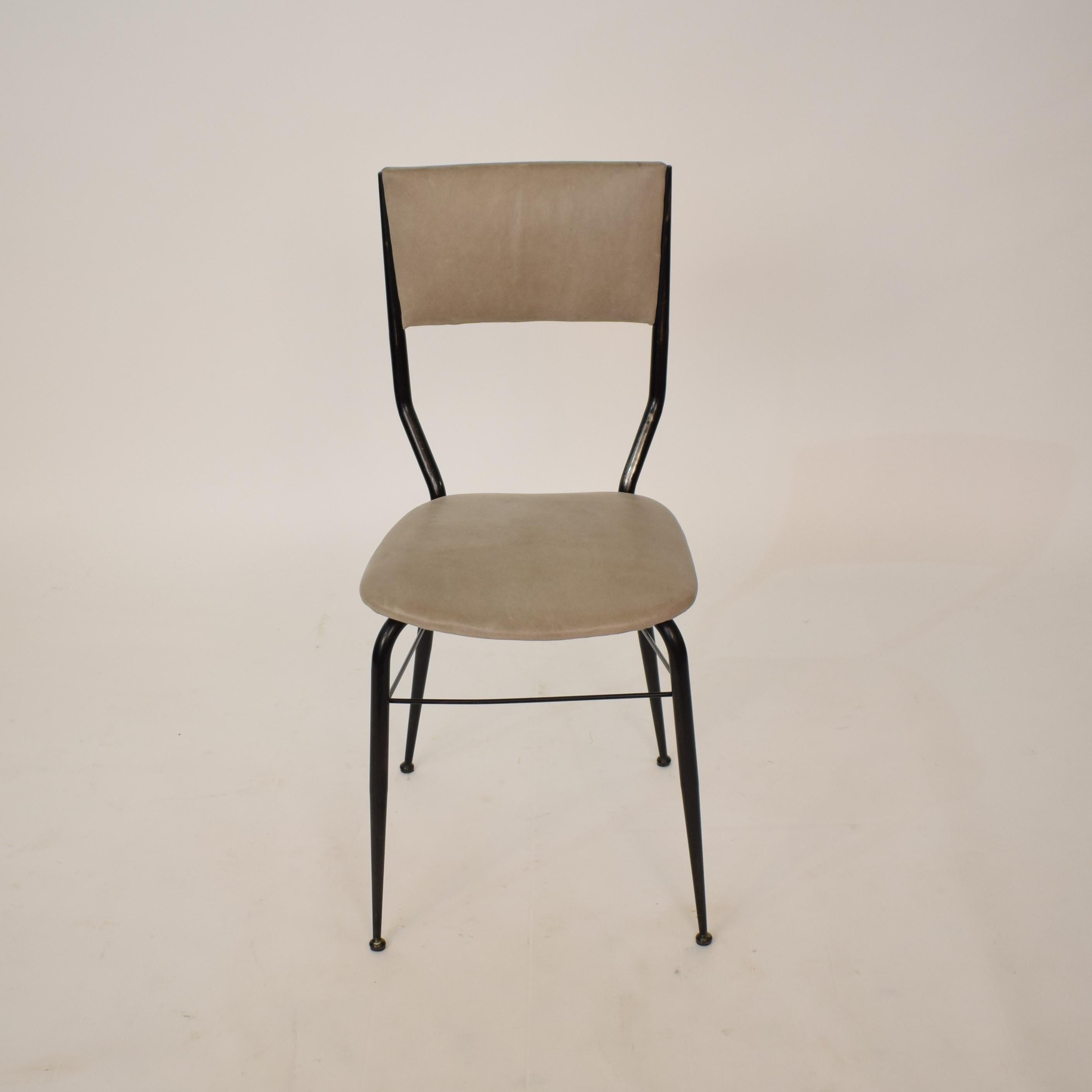 This Midcentury dining chairs from the 1950s was designed and manufactured in Italy. The chair consist of an elegant black metal frame and a padded grey leather seat and backrest. The chair has been newly reupholstered in gray leather. 
A unique