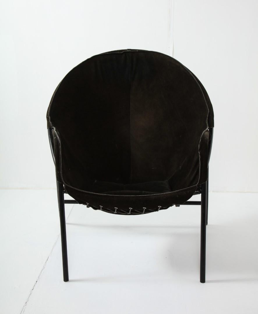 Midcentury Italian black suede balloon-shape lounge chair with black metal frame, c. 1950. Leather belt-style straps from suede to frame. Deep, low seat.